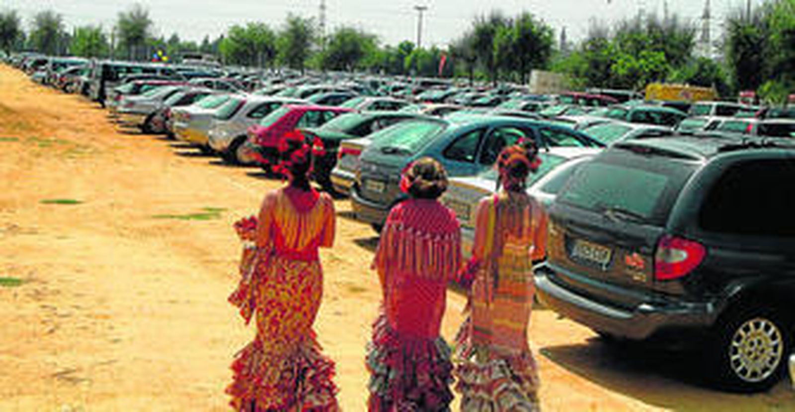 Tres flamencas pasan por uno de los aparcamientos de la Feria, en una imagen de archivo.