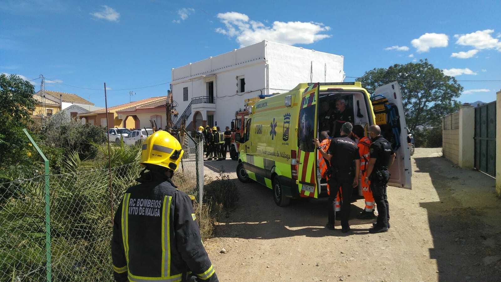 Servicio de Urgencias y Emergencias Sanitarias y Bomberos en el exterior de la vivienda incendiada