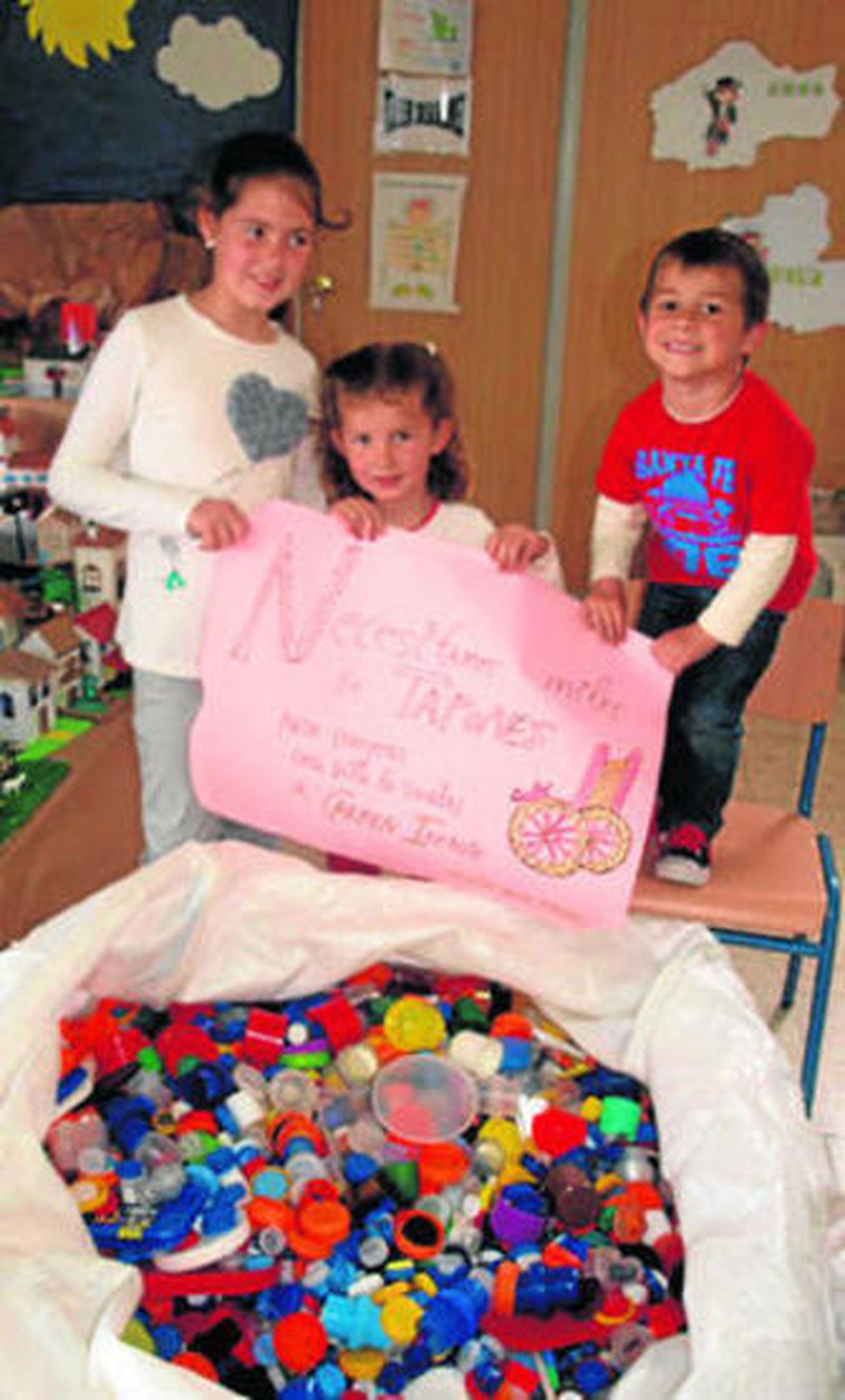 Los sobrinos de Carmen con la saca de tapones en el colegio Aljibe.