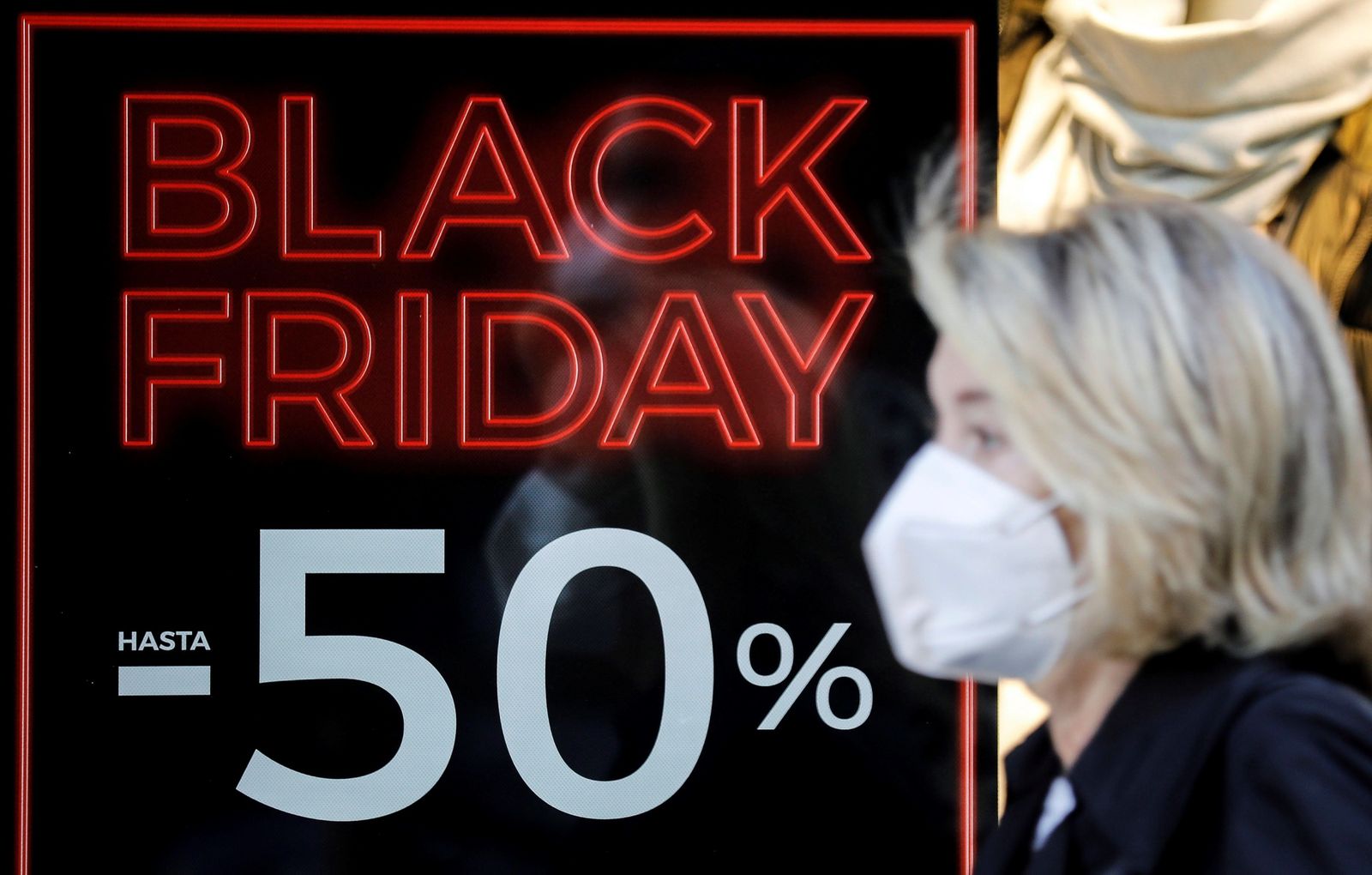 Una mujer pasa frente a un comercio con descuentos por el Black Friday