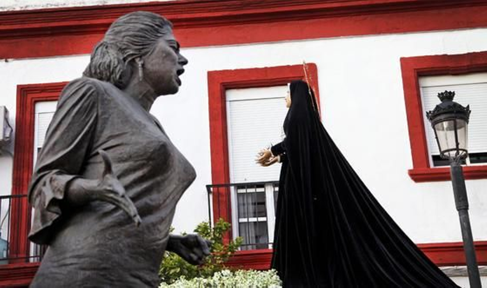 Singular imagen de Nuestra Señora de Amor y Sacrificio en su pasar por la calle Sol junto a la estatua de La Paquera de Jerez.

Foto: Vanesa Lobo