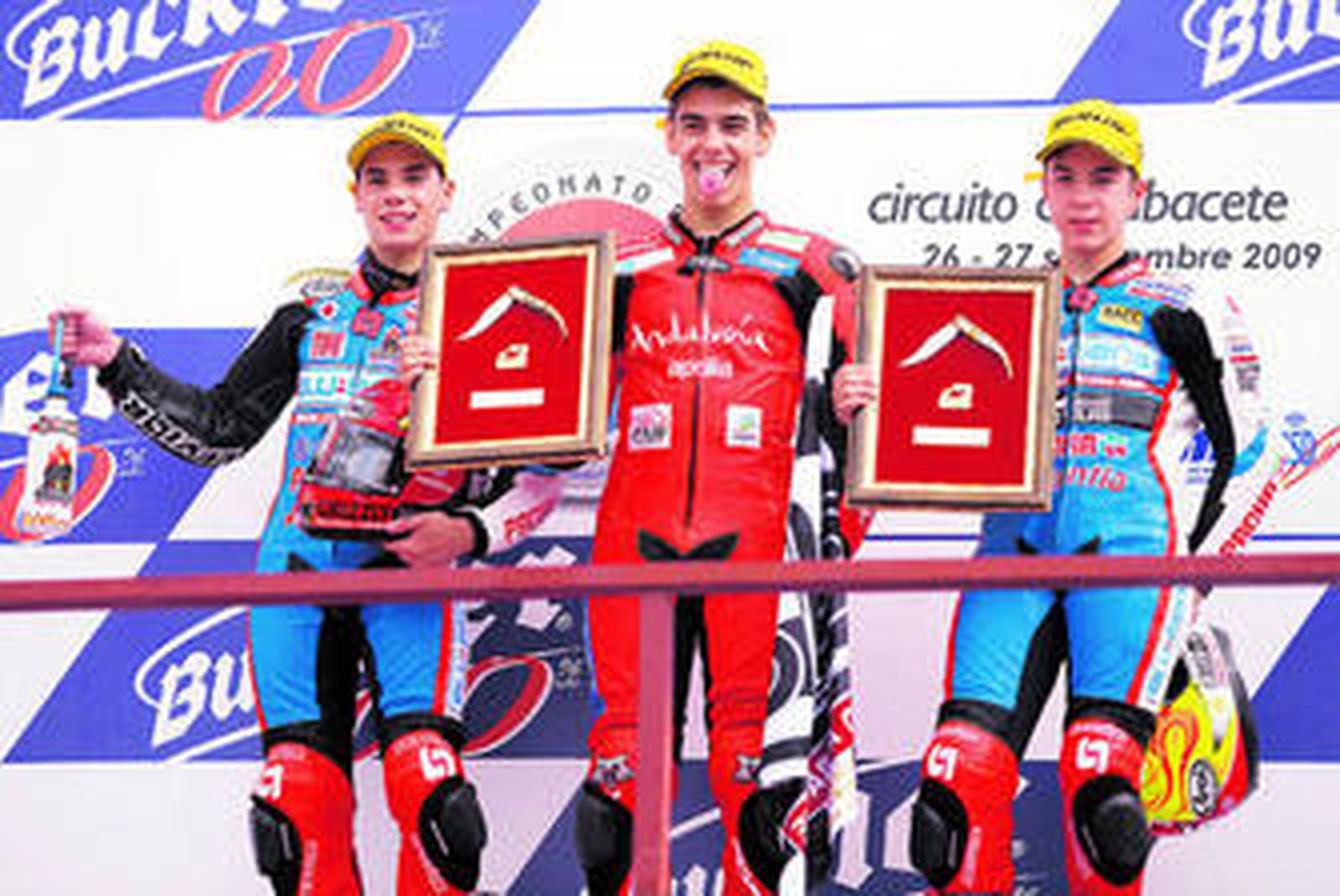 Moncayo bromea en el podio junto a Oliveira (i) y Viñales.