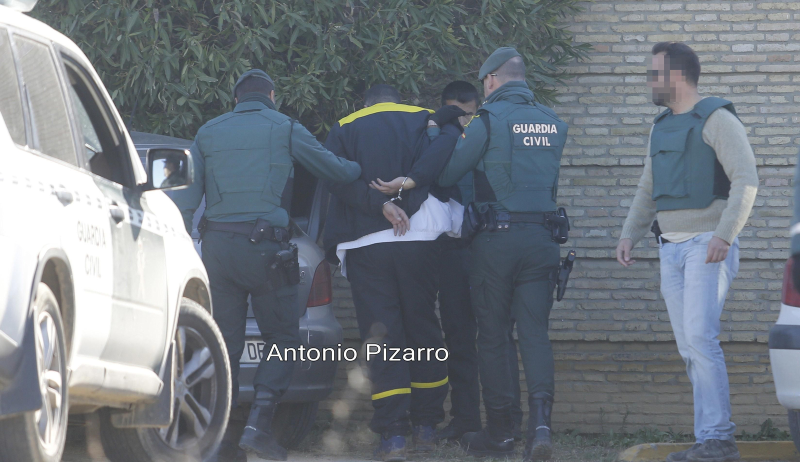 Uno de los detenidos es conducido por la Guardia Civil a la salida del chalé