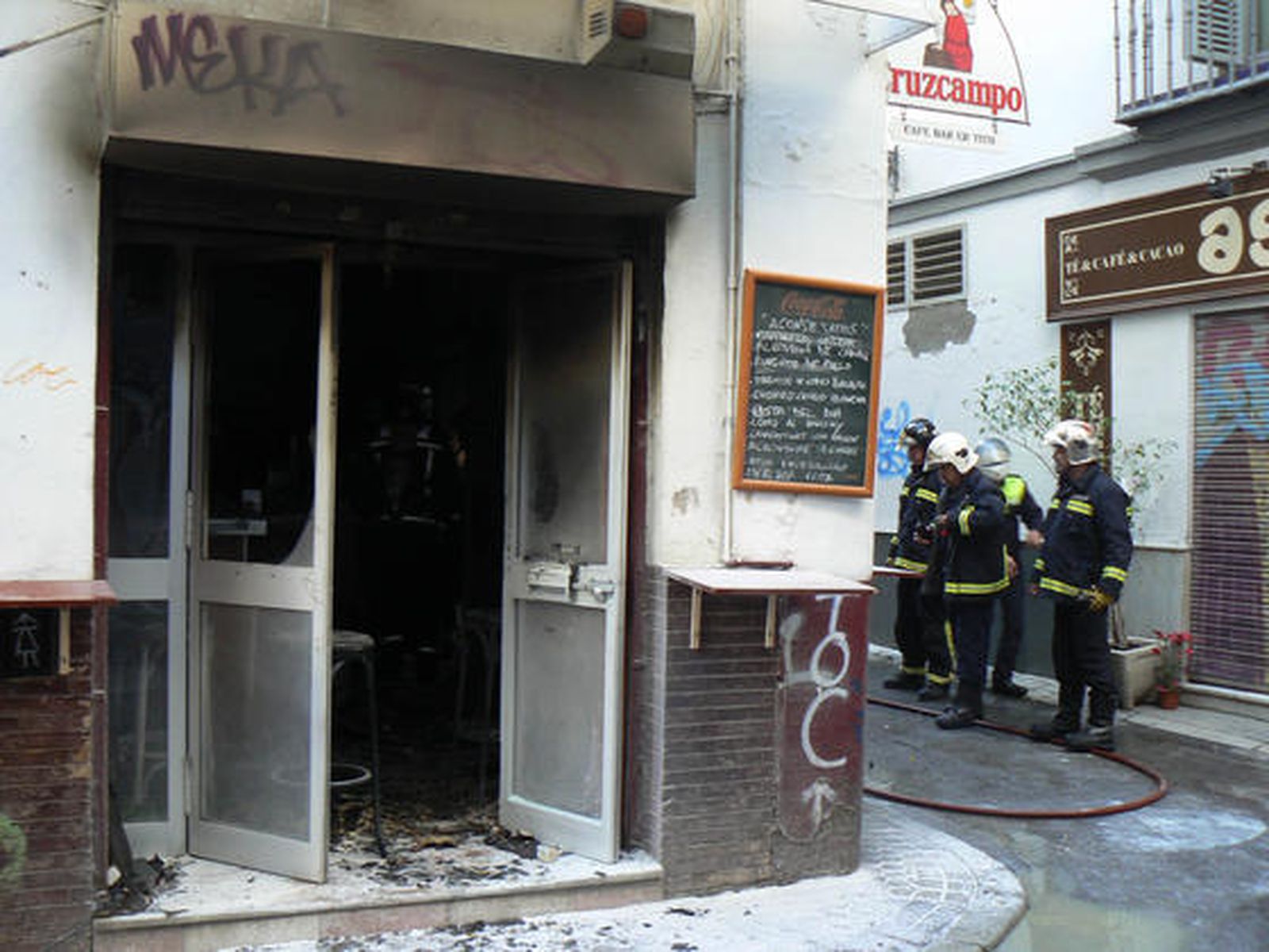 La puerta principal del bar Er Tito ha quedado totalmente calcinada.

Foto: Ruesga Bono/José Ángel García