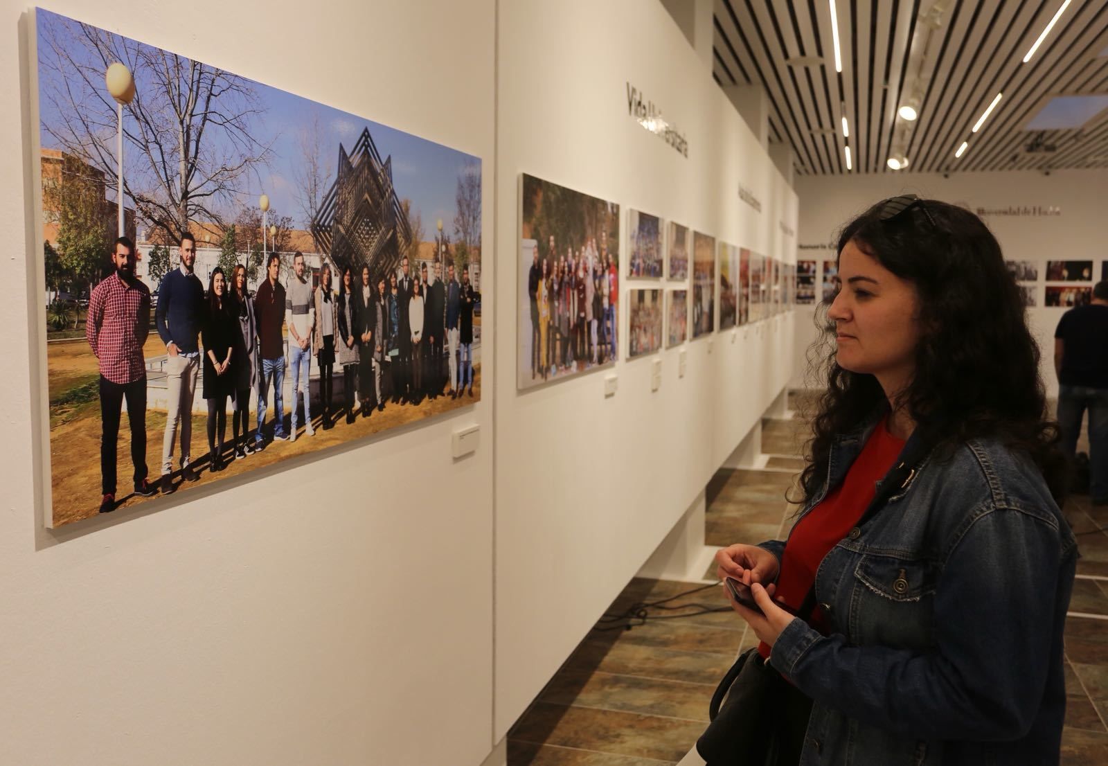 Una joven observa una fotografía de la exposición.