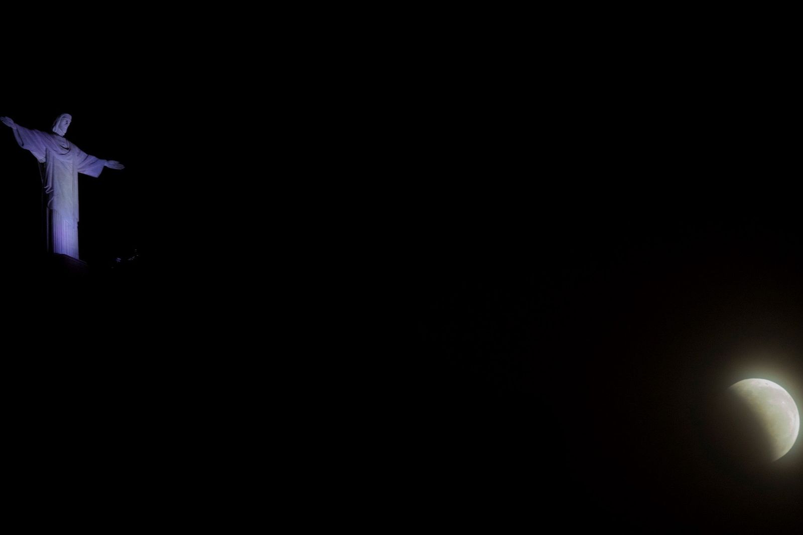Vista de la luna con la estatua de Cristo Redentor en la ciudad de Río de Janeiro.