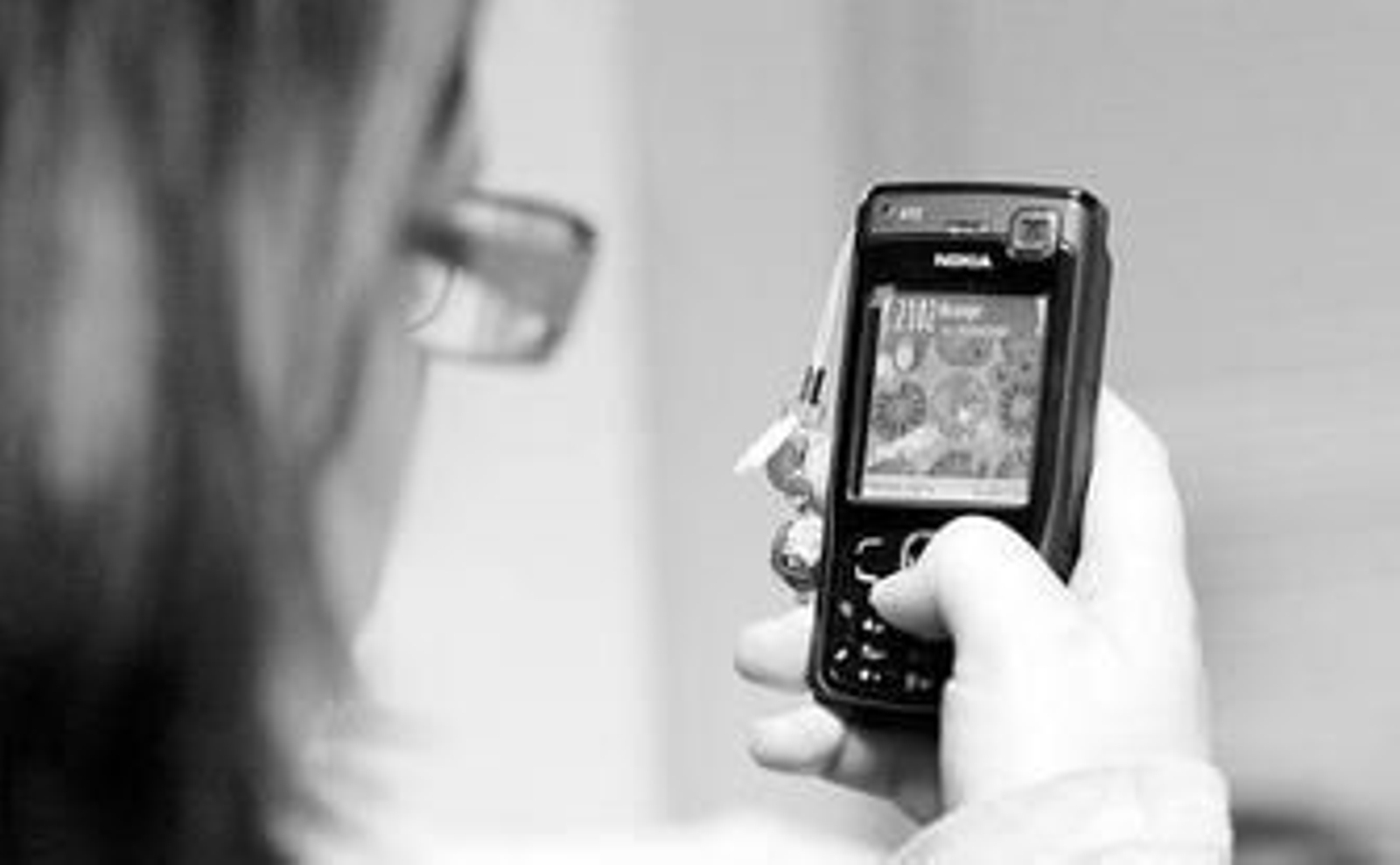 Una chica realiza una llamada con un móvil.