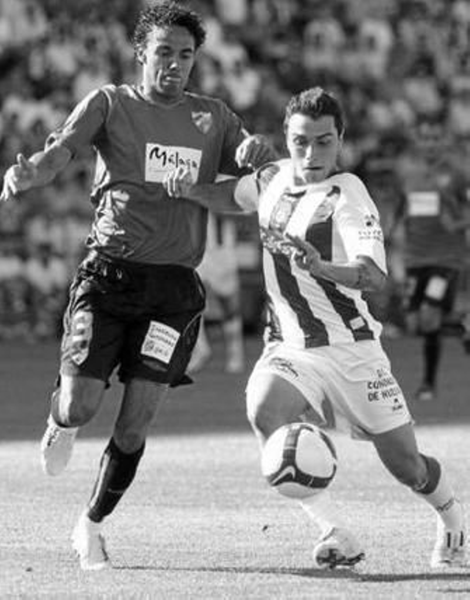 Adrián Colunga conduce la pelota ante el malaguista Welligton.