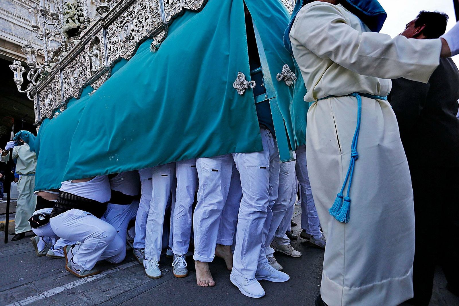 Cargadores de la Virgen del Patrocinio levantan el paso en la calle.