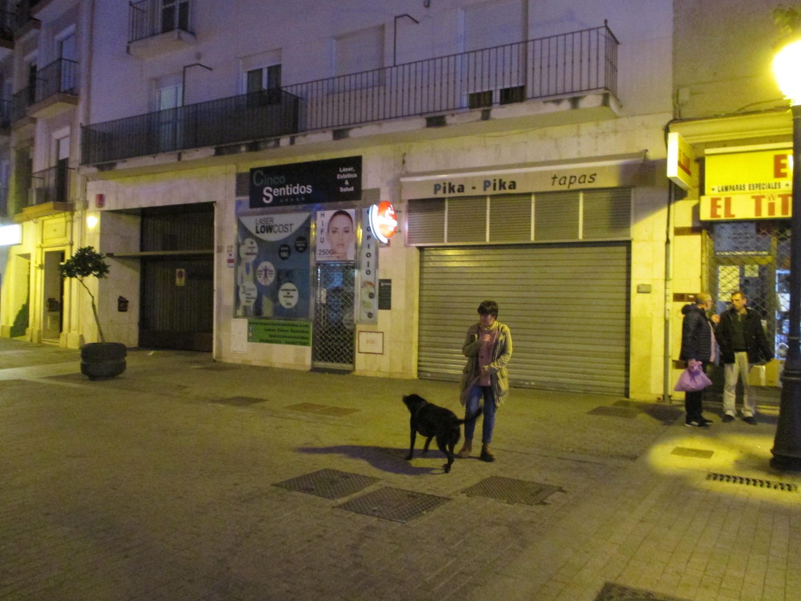 Una mujer pasea a su perro frente al bloque de pisos del suceso.