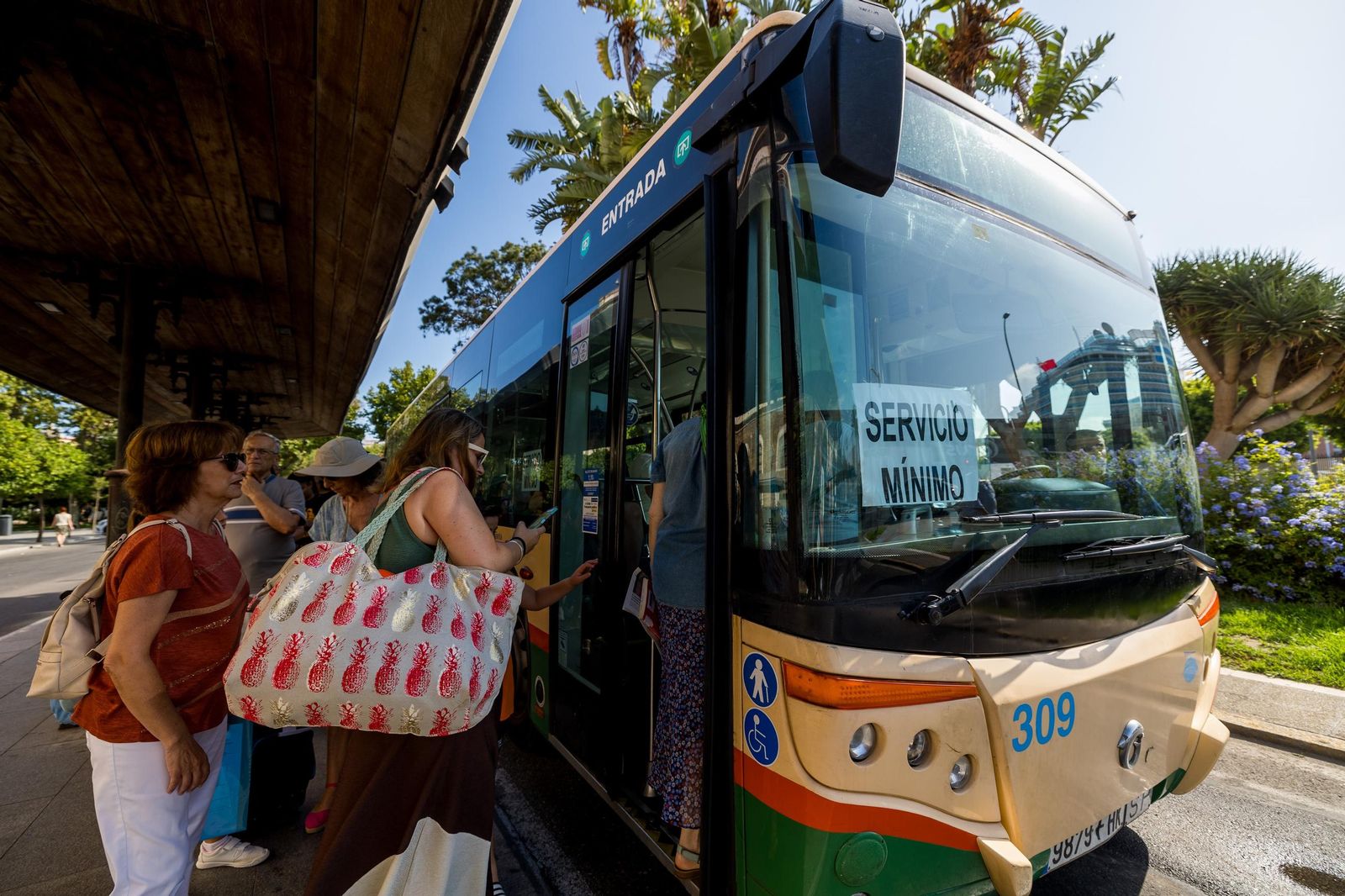 Un vehículo incluido en los servicios mínimos carga viajeros en la plaza de España.