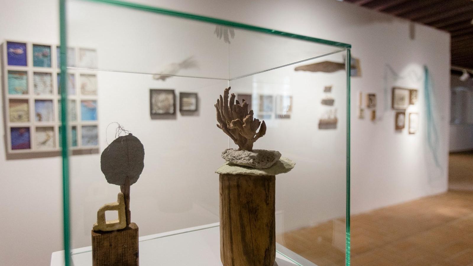 En primer plano, vitrina con una de las pequeñas esculturas de 'Con la tinta de calamar' de Marisa Bascuñana.