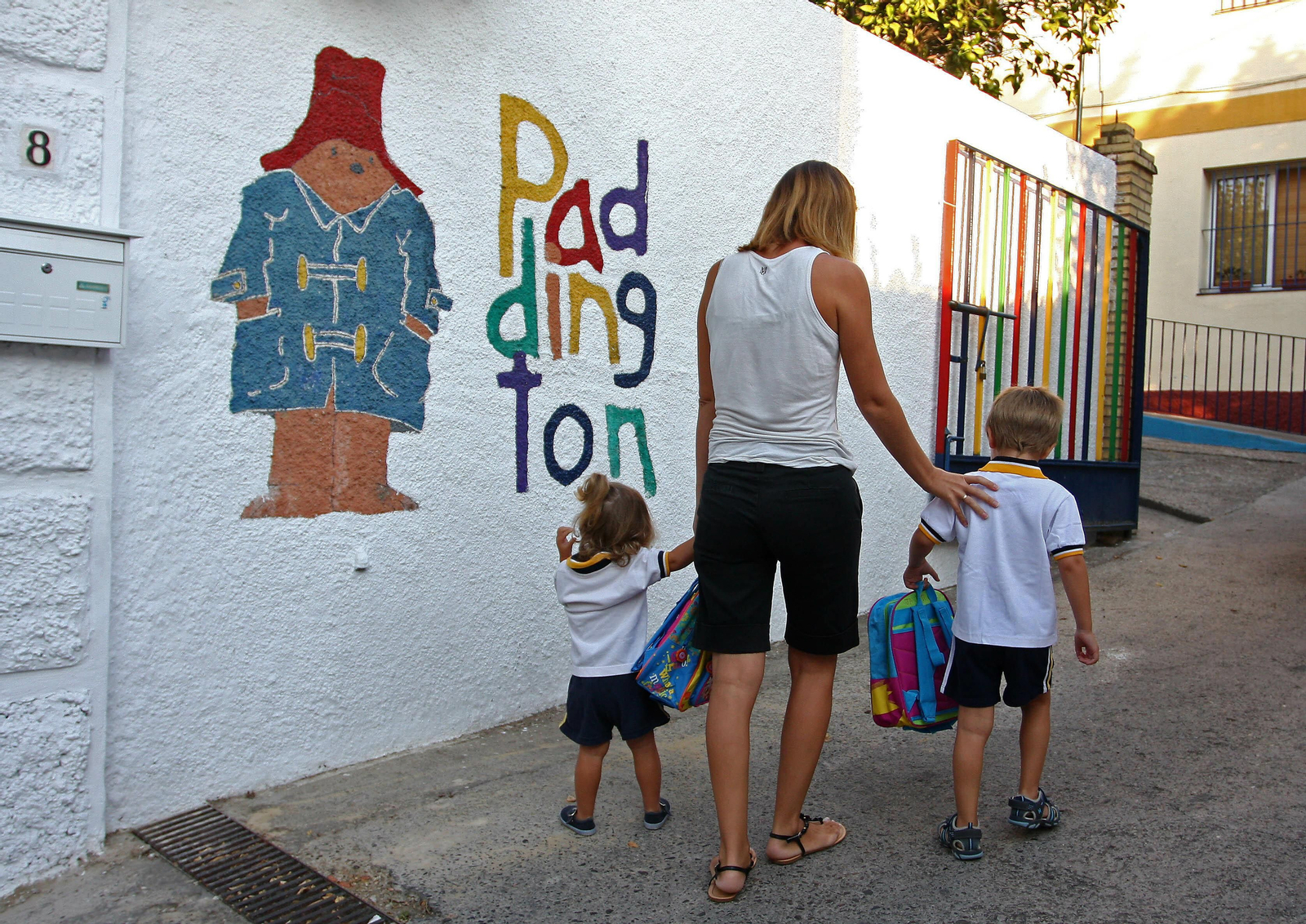 Una madre acompaña a sus hijos a la guardería.