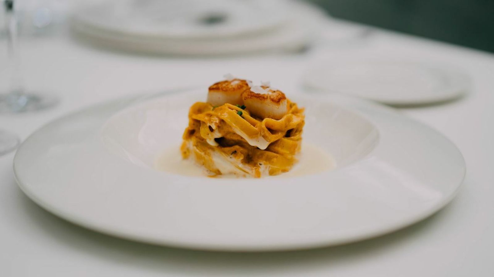 Tagliatelle con txangurro y vieira sobre salsa de cava.