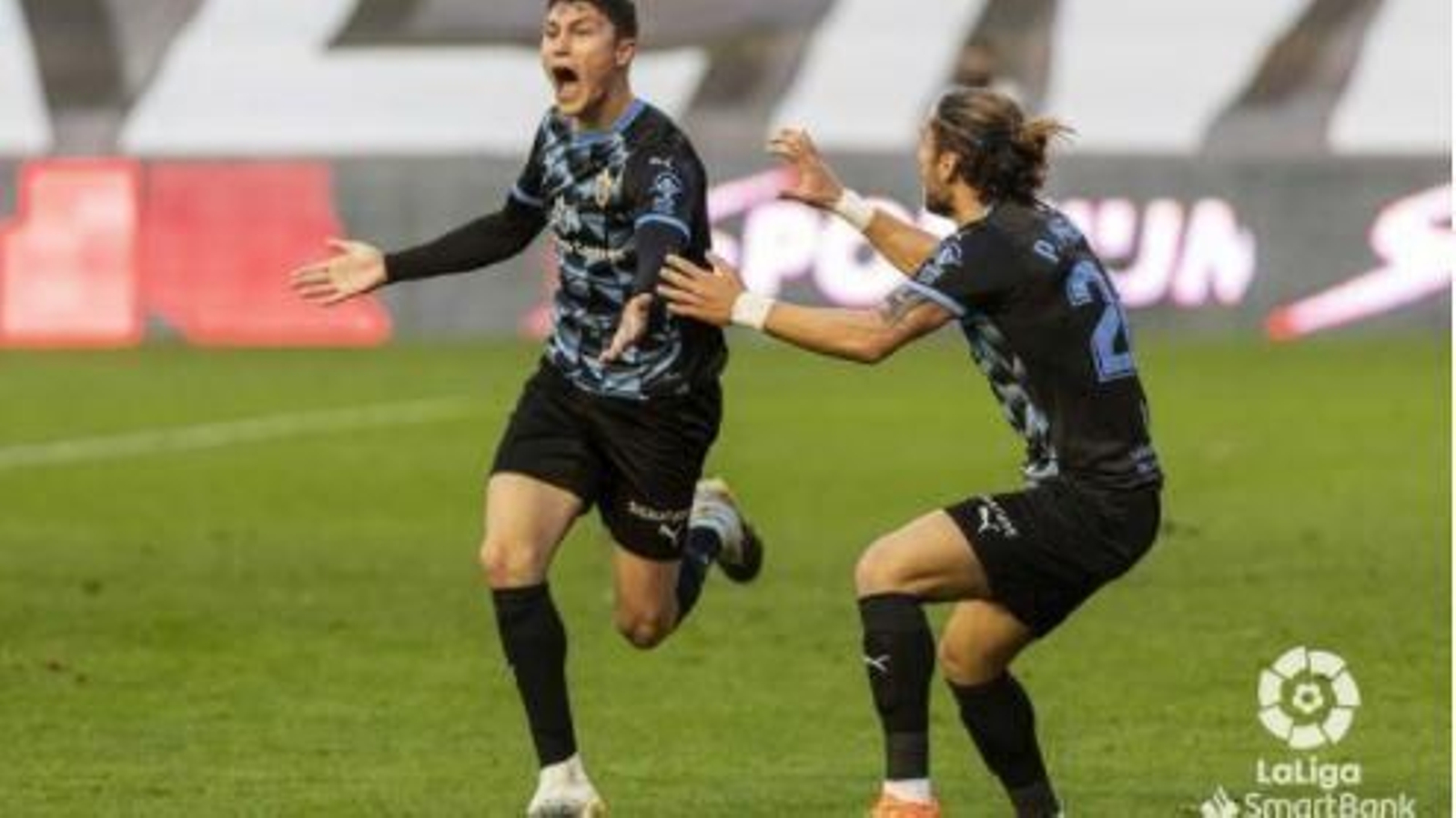 Mendes trata de abrazar a Cuenca tras el gol de éste en Vallecas.