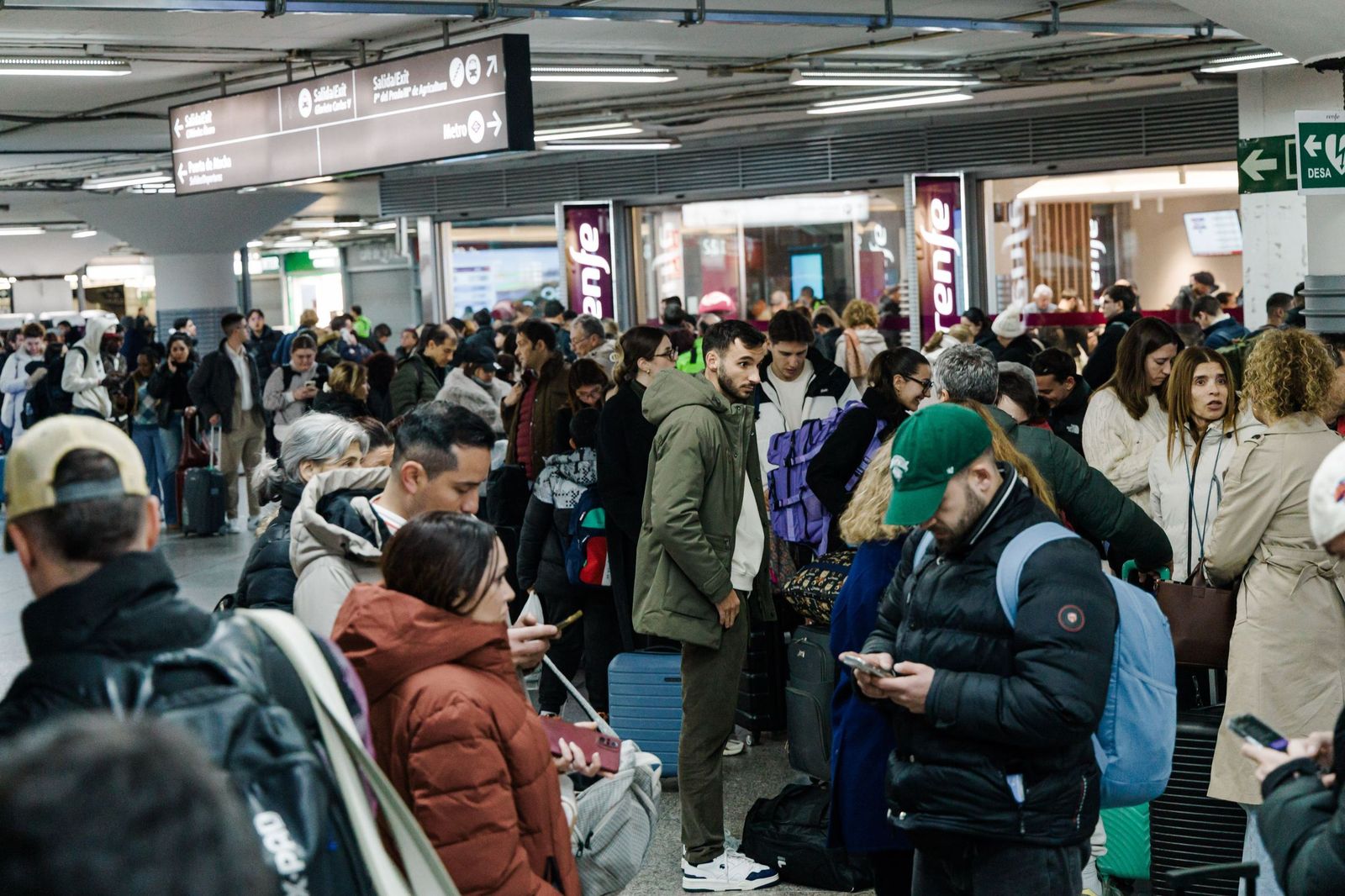 Grupos de viajeros afectados, en la noche de este domingo en la estación de Atocha.
