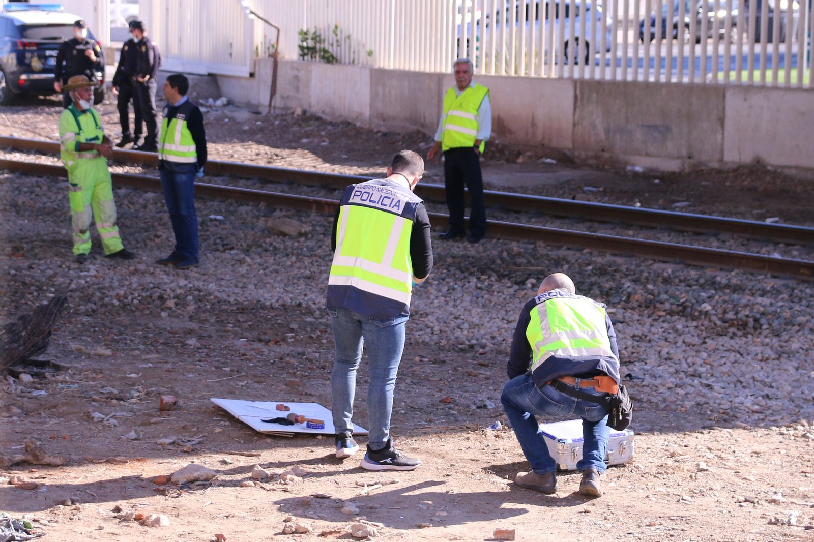 Agentes de la Policía Judicial y de la Policía Científica de la Comisaría de Almería durante la inspección de las vías del tren y del terreno colindante