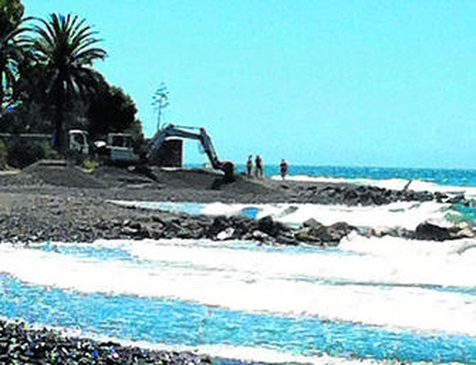 Al fondo, trabajos de aporte de arena en una de las playas del municipio.