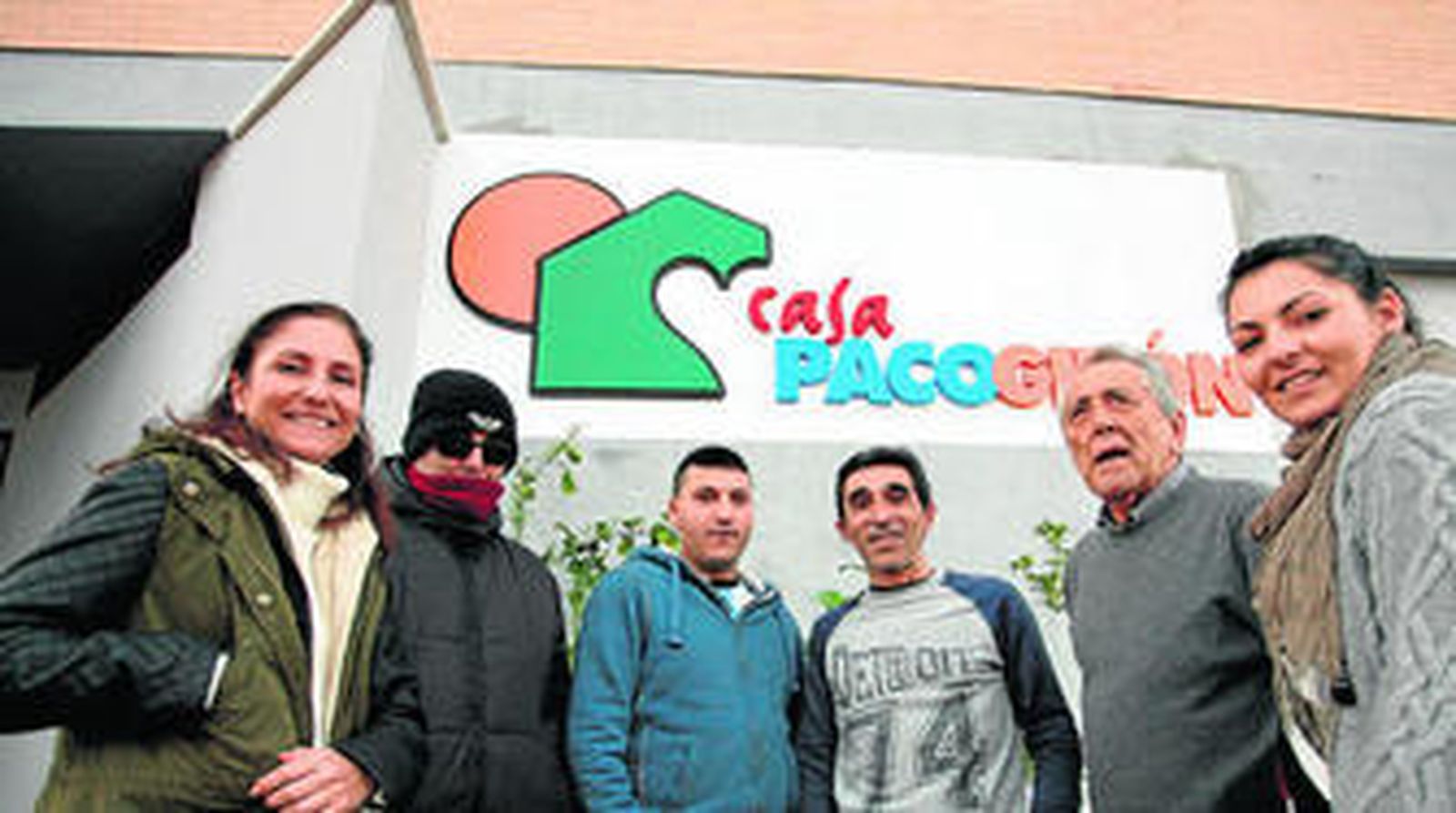 1. Responsables y beneficiarios, en la entrada de la casa. 2. Mohamed muestra su dormitorio, del que él es responsable, junto a la presidenta.  3. El vicepresidente, Jesús González, prepara la merienda con Adrián.  4. Fachada del edificio, en la avenida Pablo Ruiz Picasso. 5. Vicente García ayuda a Djibril con la informática. 6. May Villarrubia atiende a  las explicaciones de uno de los beneficiarios.