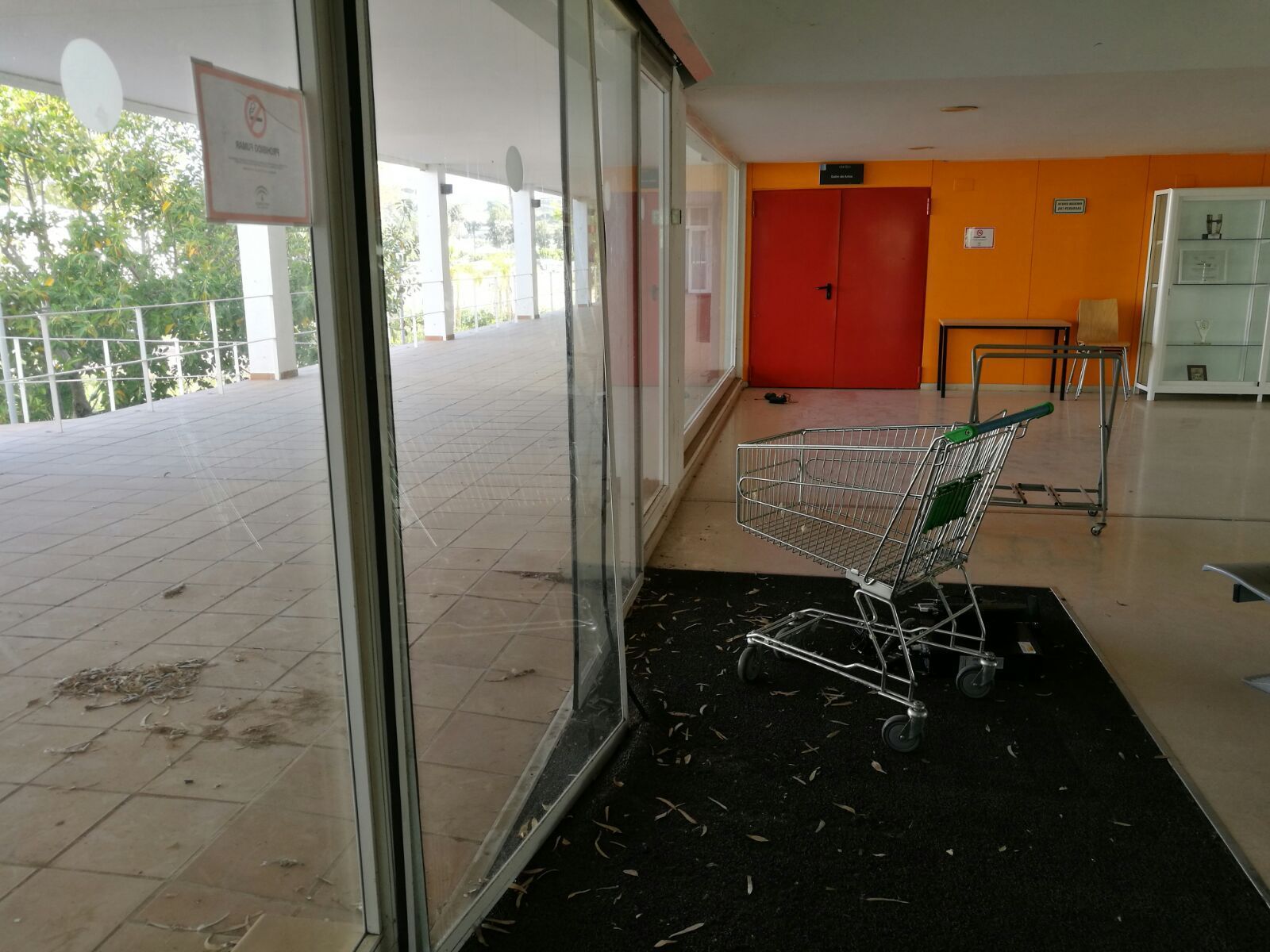 Una de las puertas principales de acceso al centro, completamente forzada.