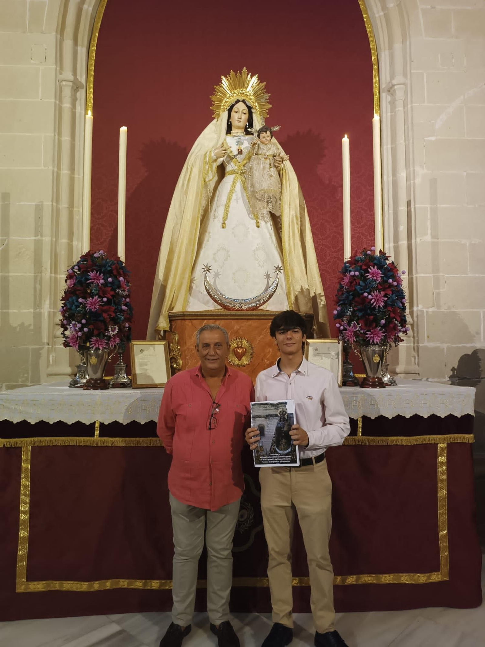 El joven, entregando al Hermano Mayor del Rosario la marcha creada.
