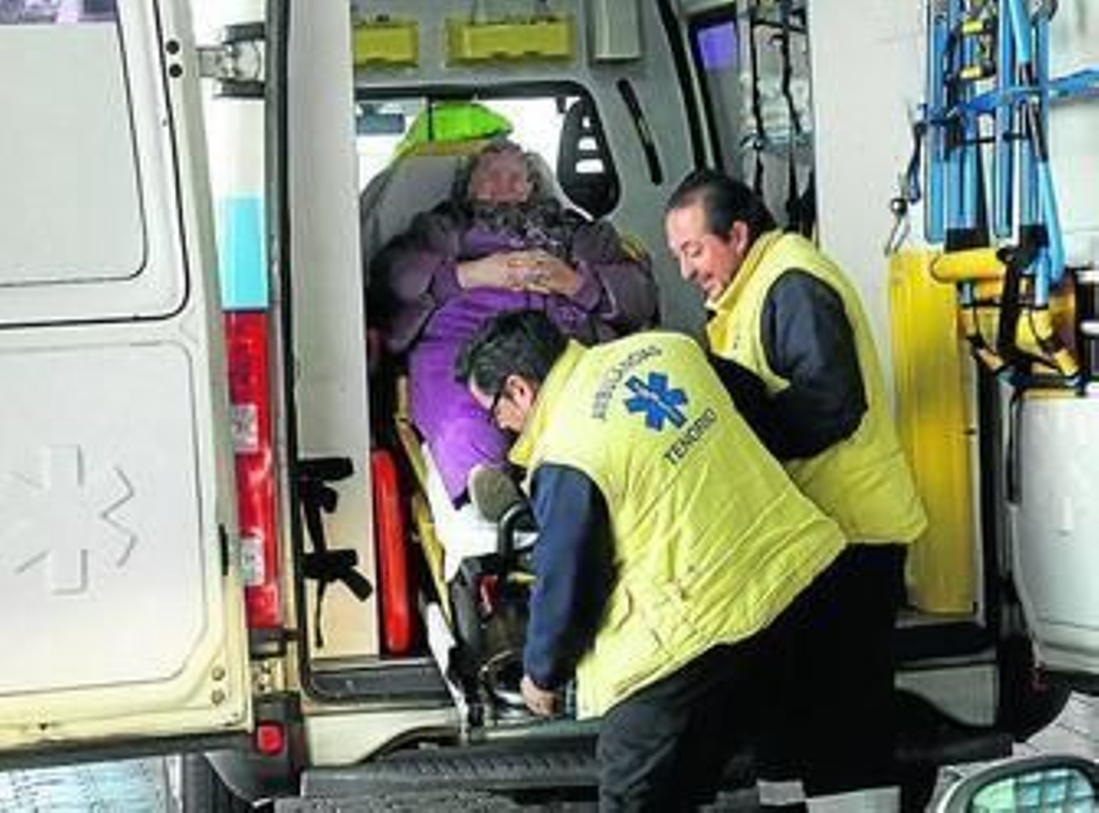 Dos técnicos de Urgencias trasladan a una paciente a Urgencias.