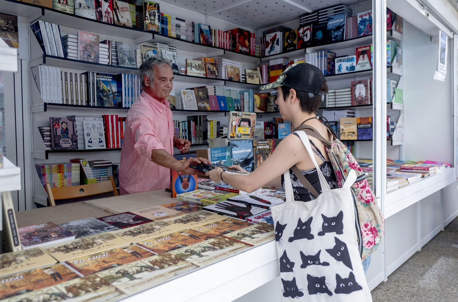 Una joven adquiere un libro en una feria.