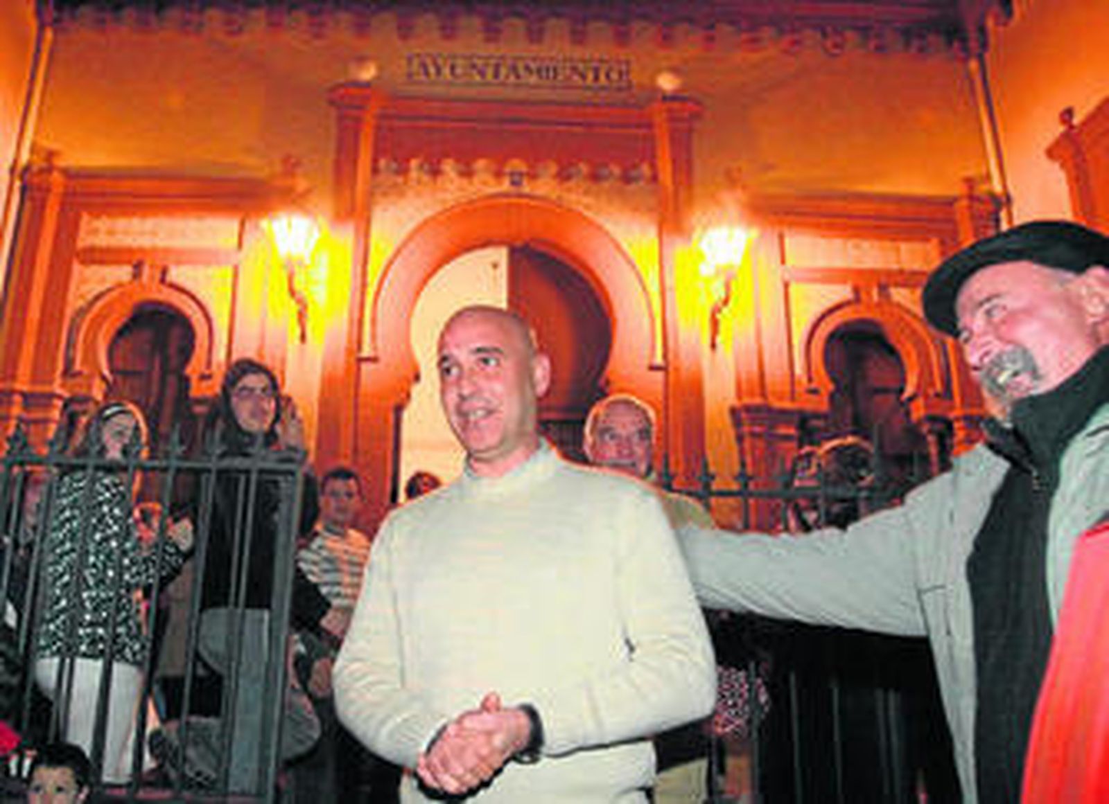 Óscar Román (izquierda) saludado por un vecino, el día que abandonó la alcaldía.