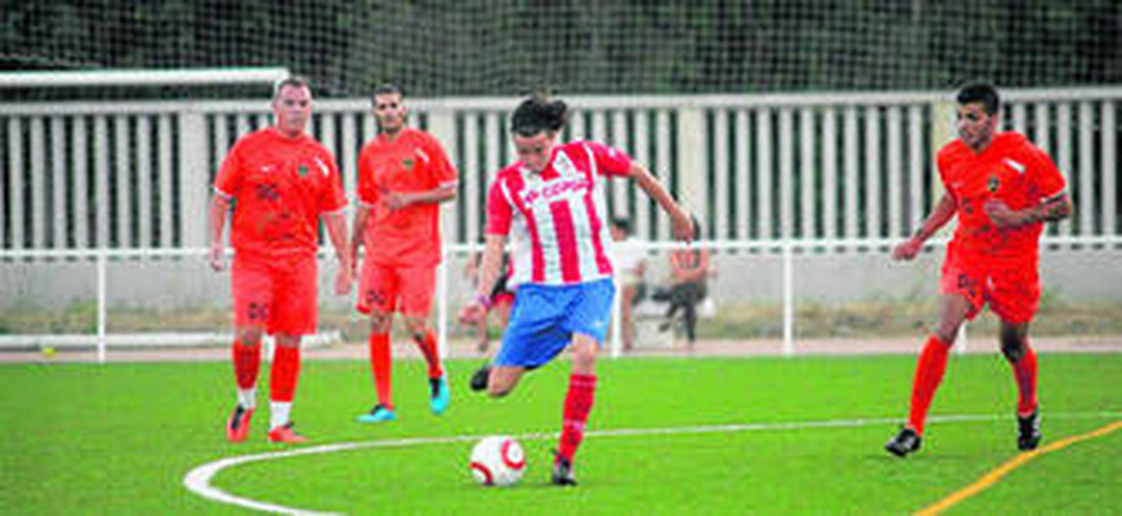 Javi Chico golpea el balón ante tres jugadores del PollosDG.