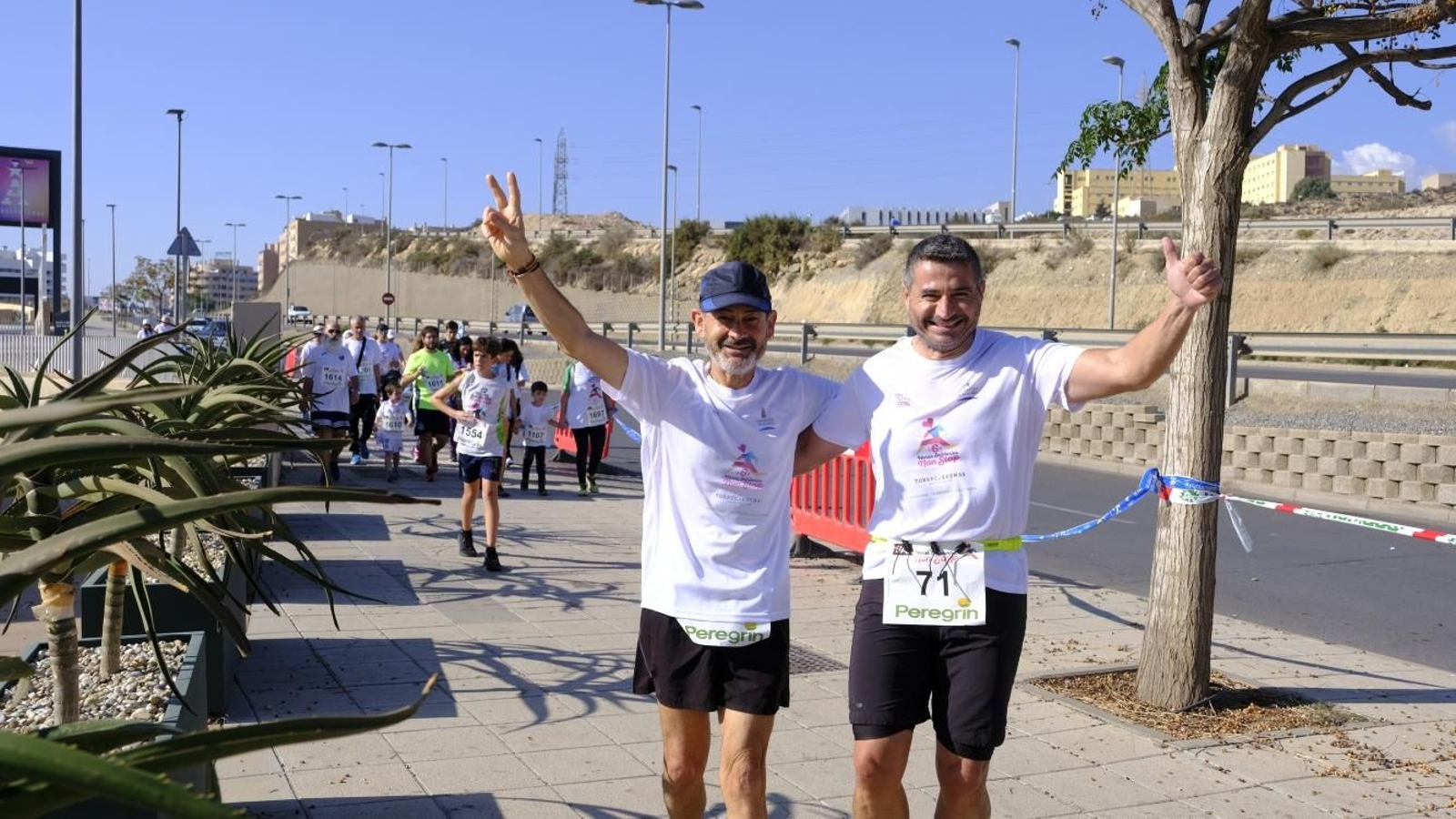 Dos participantes saludan en mitad de esta prueba solidaria.
