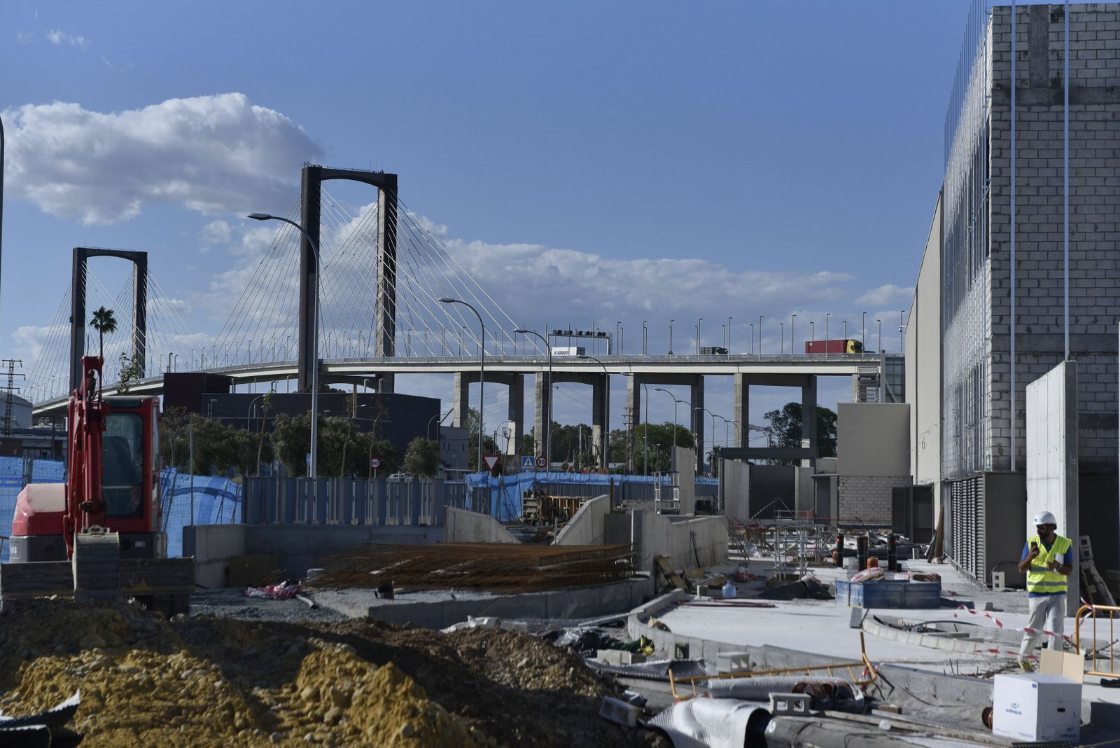 Construcción del centro comercial Palmas Altas con el puente del Centenario, punto clave de la SE-30, al fondo.