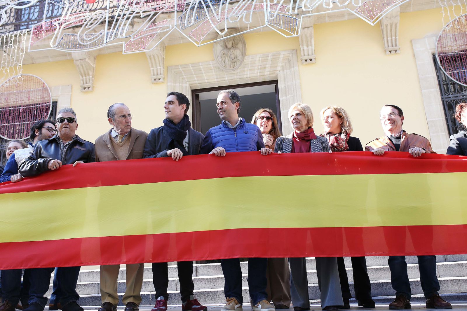 Militantes del PP portan la pancarta ante el Ayuntamiento.