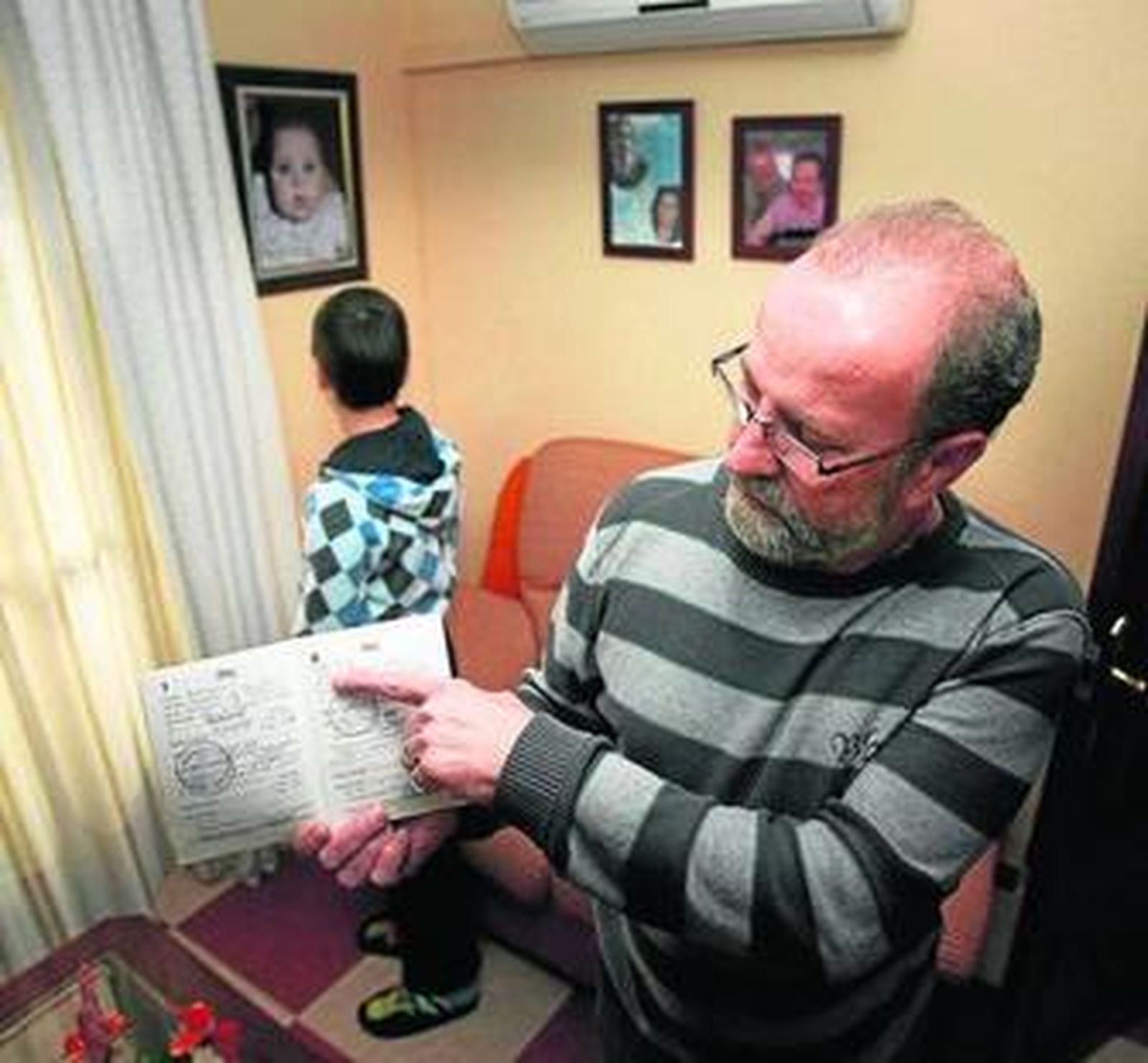 Antonio Heredia, ayer, muestra el libro de familia, en el que aparecen registrados los gemelos.