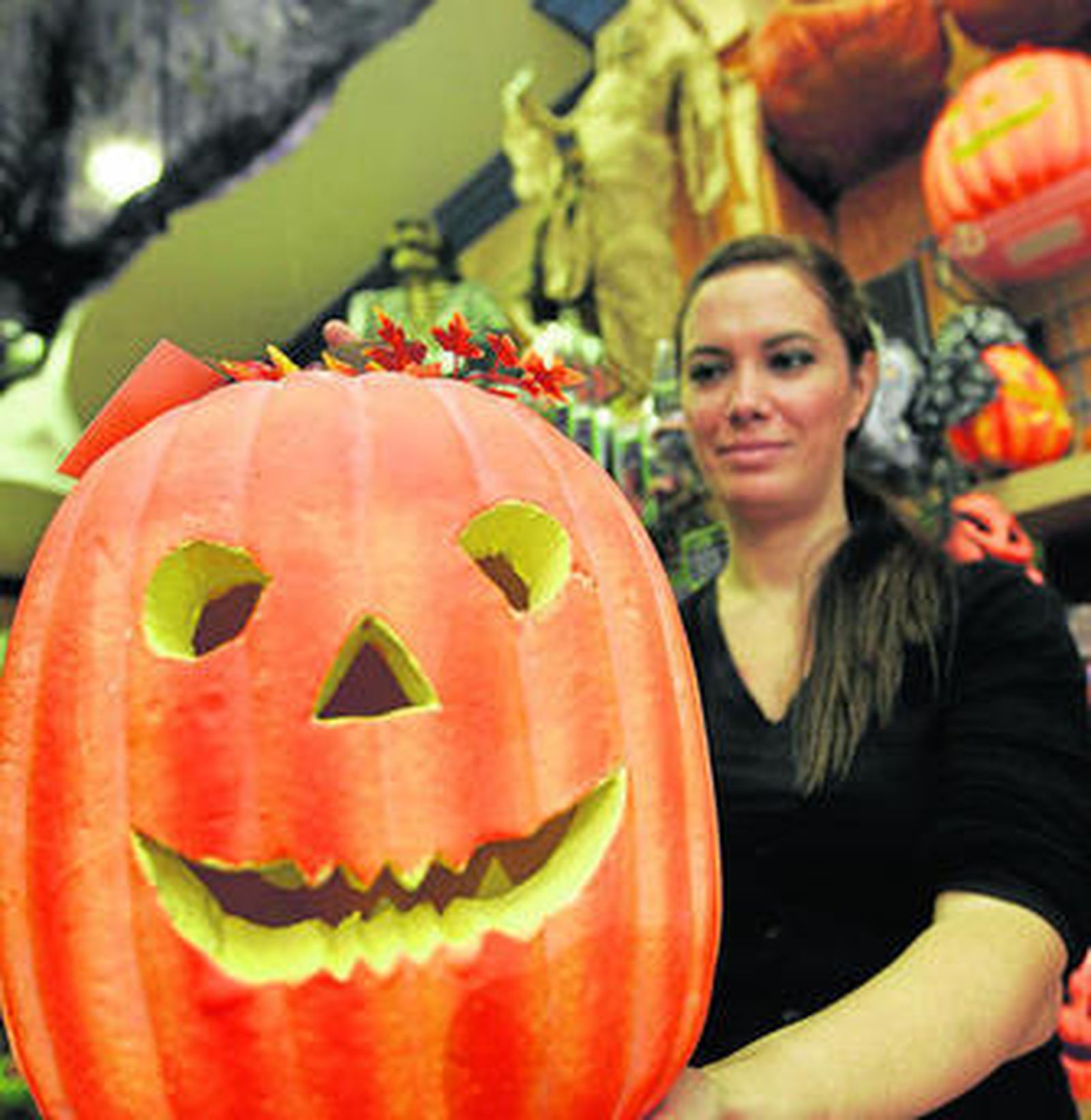 La dependienta Belén Fernández muestra una de las calabazas de Halloween.