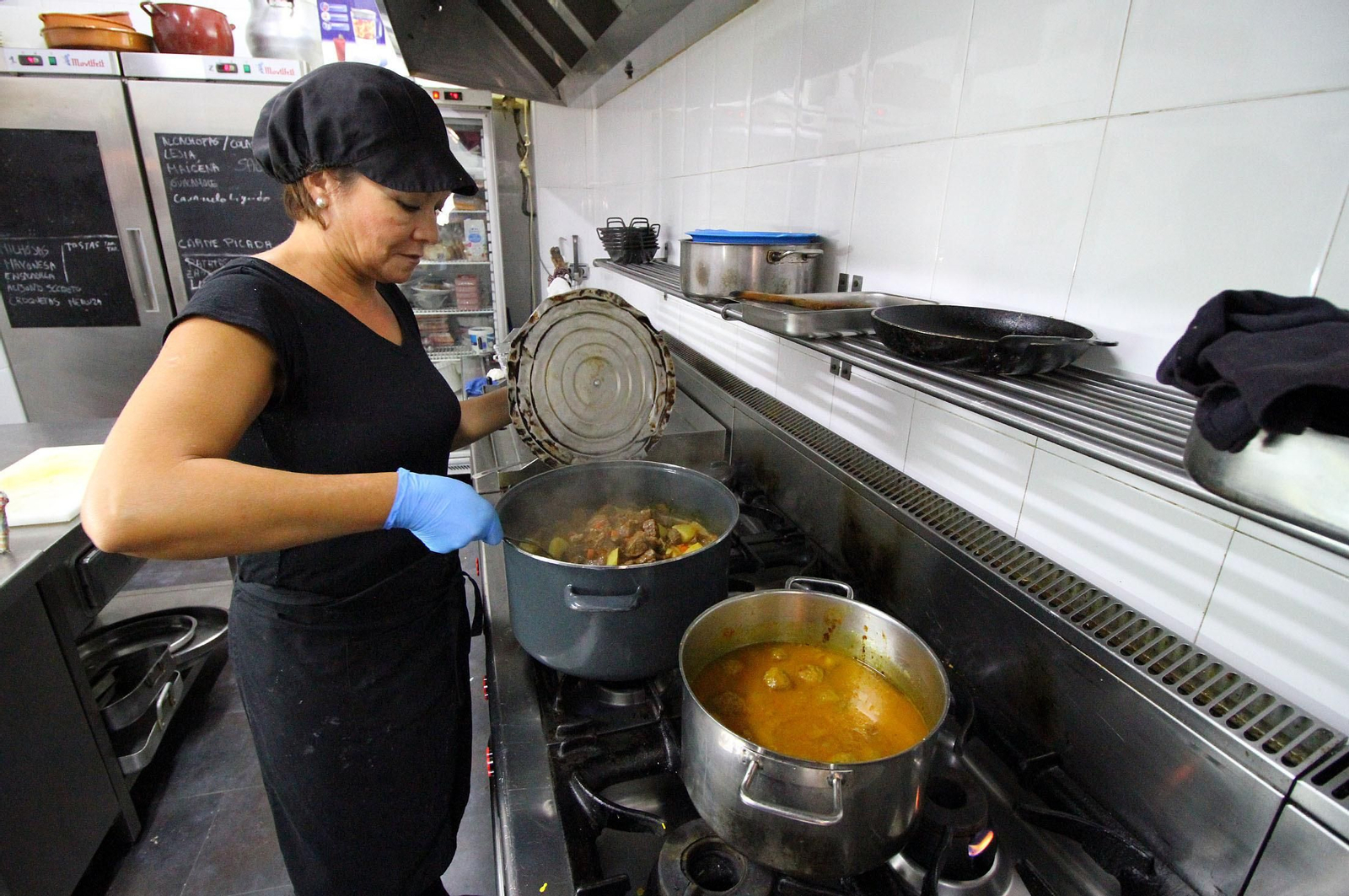 Una cocinera prepara un menú.