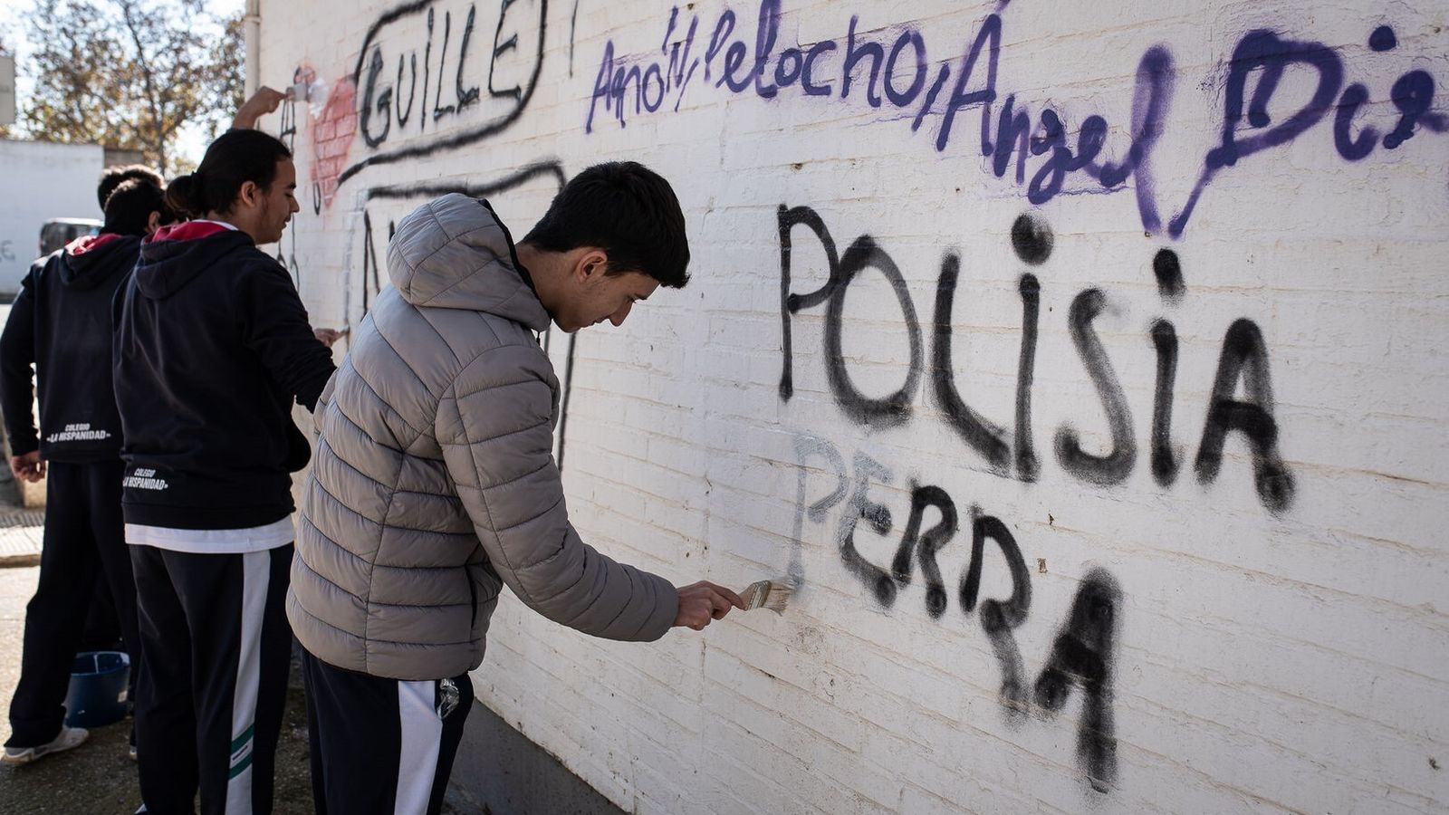 Estudiantes de La Hispanidad quitan pintadas de una fachada.