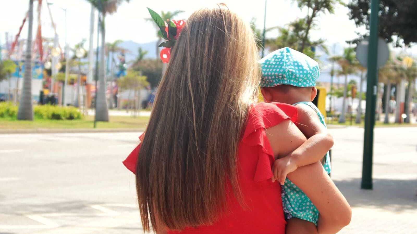 Una mujer con un bebé en brazos.