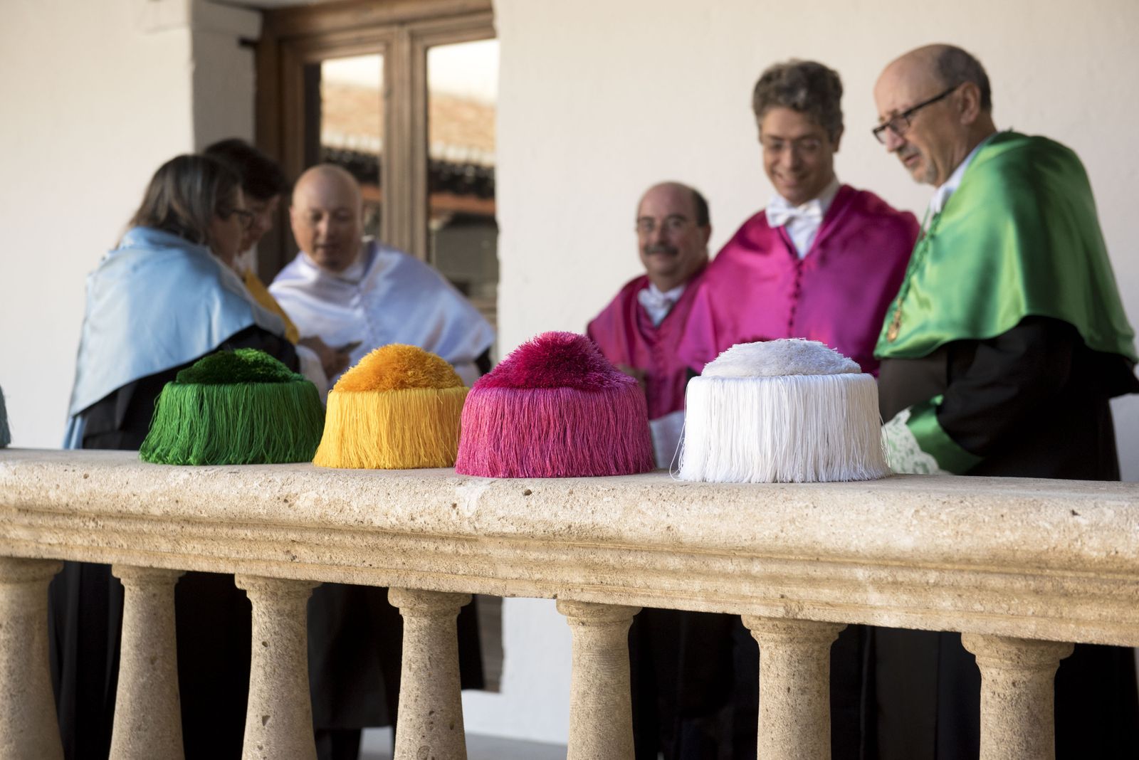 Los birretes sobre una de las barandas de piedra del Hospital Real.
