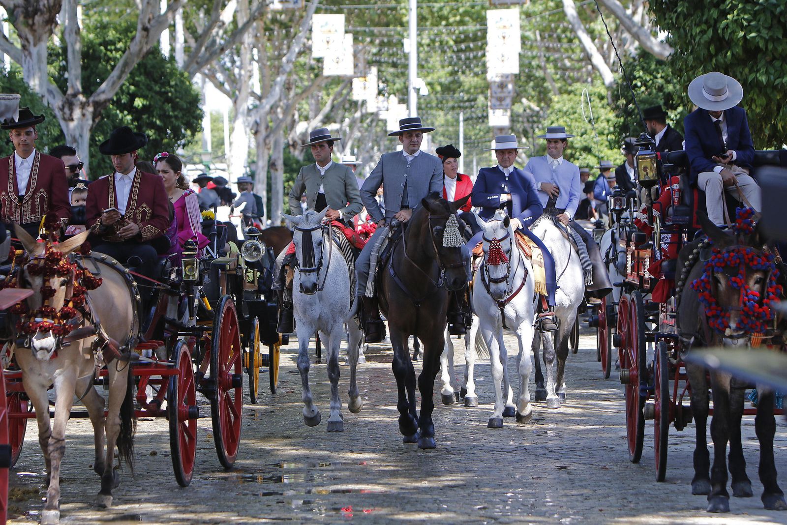Grupos de caballistas montan relajados por las calles del real.