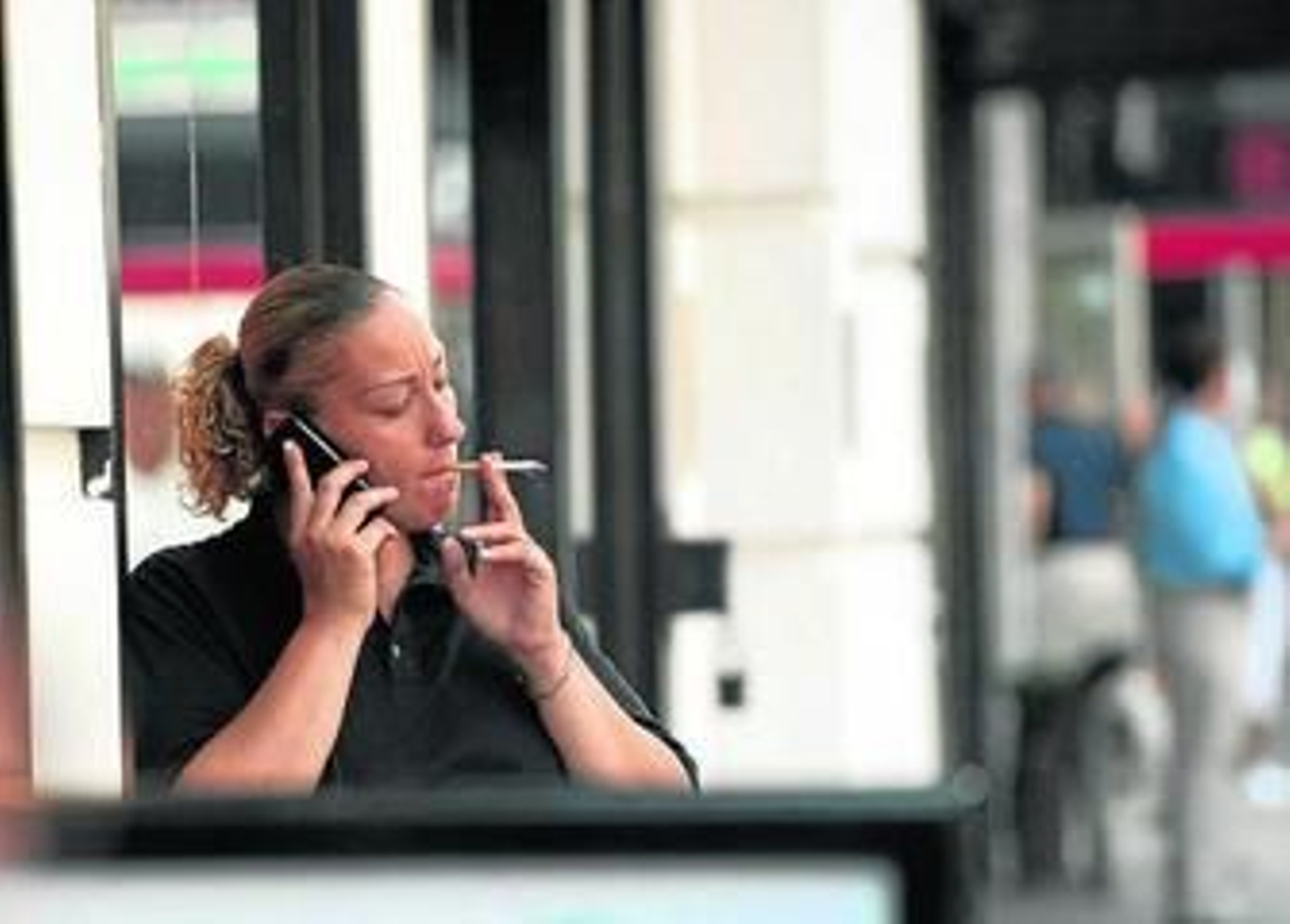 Una trabajadora fuma un cigarrillo en la puerta de su oficina.