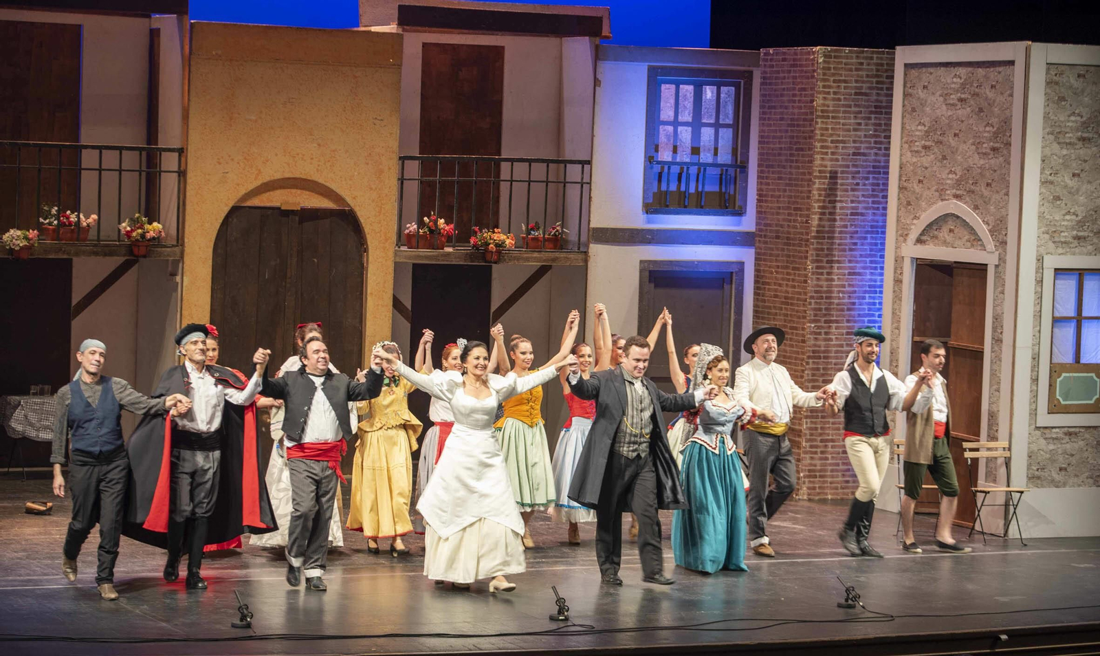 El elenco de artistas que participan en la zarzuela saluda al público.