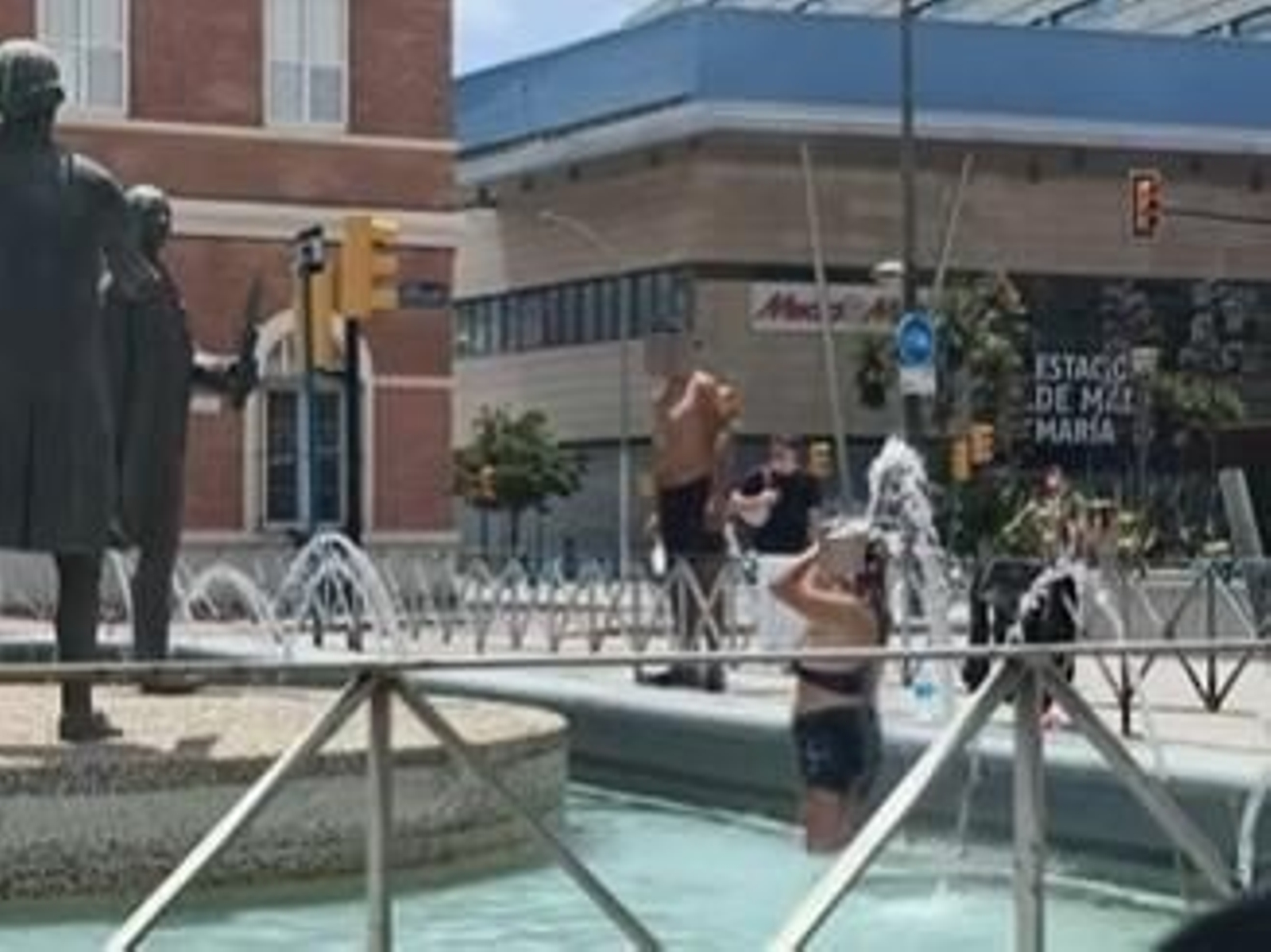 Dos personas se dan un chapuzón en una fuente junto a la estación María Zambrano.