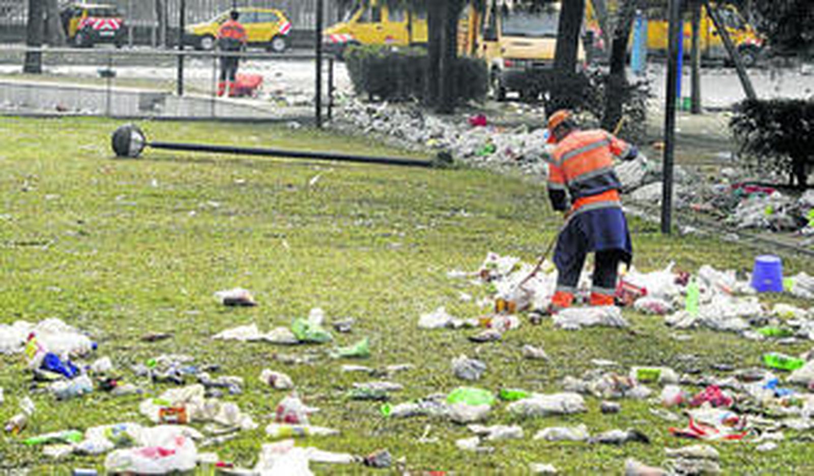 Un empleado de Lipsam recoge los restos de una botellona en la Cartuja, en una imagen reciente.