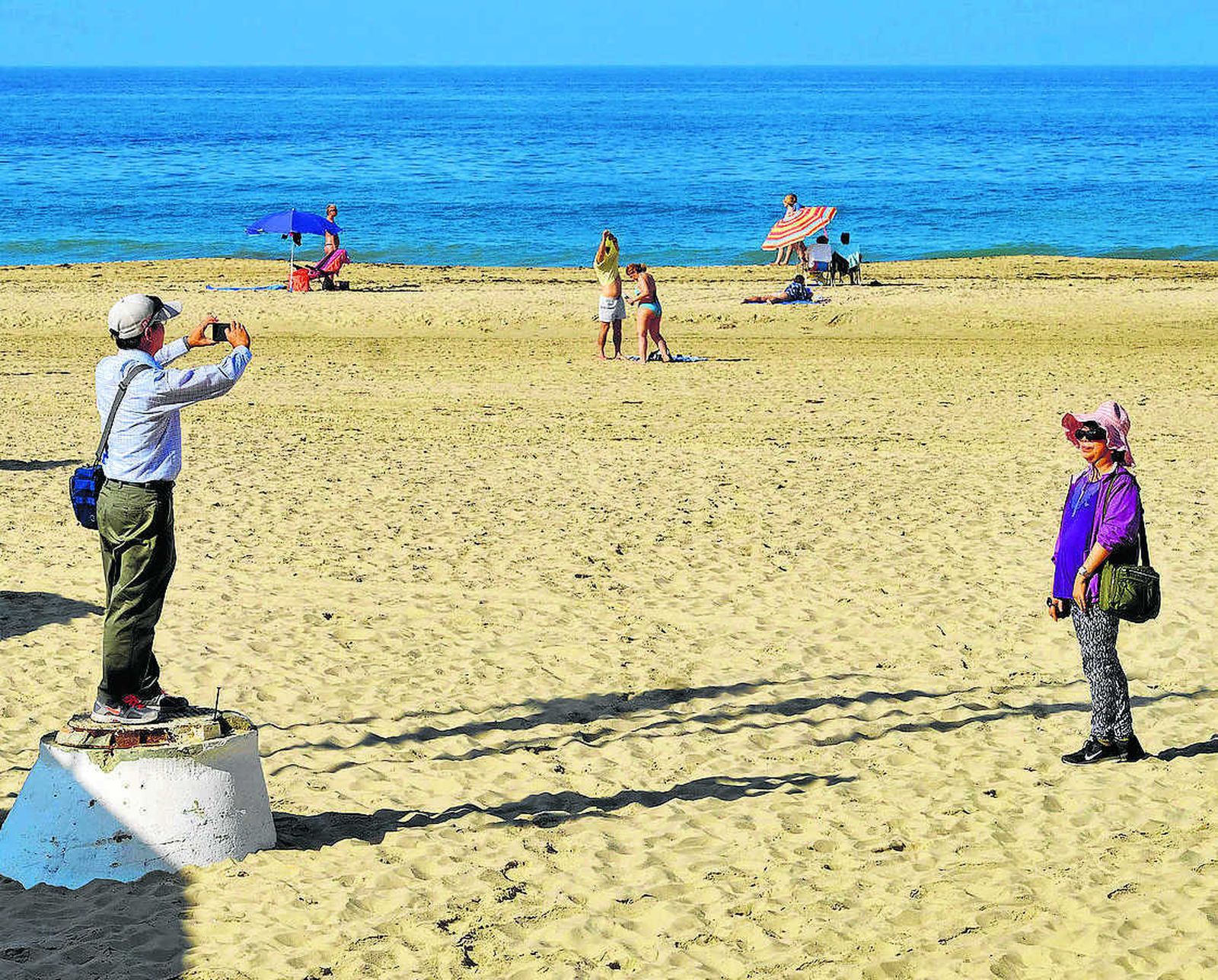 La toma de fotografías, una imagen habitual en las playas de Cádiz.
