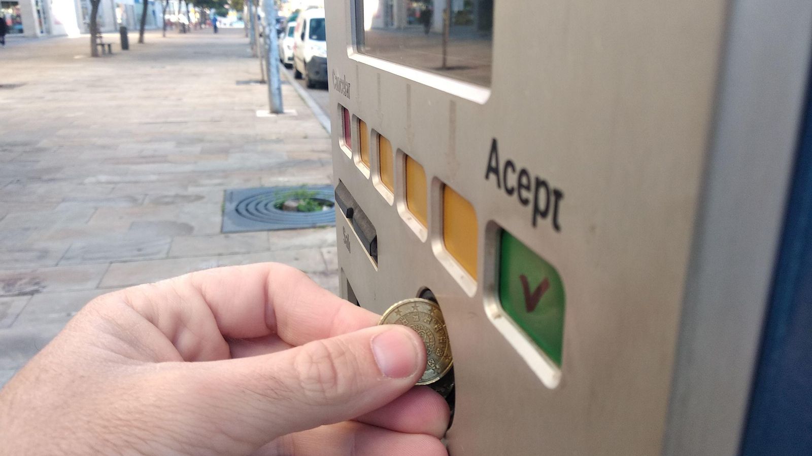 Una persona realiza el pago de la tarifa en un parquímetro.