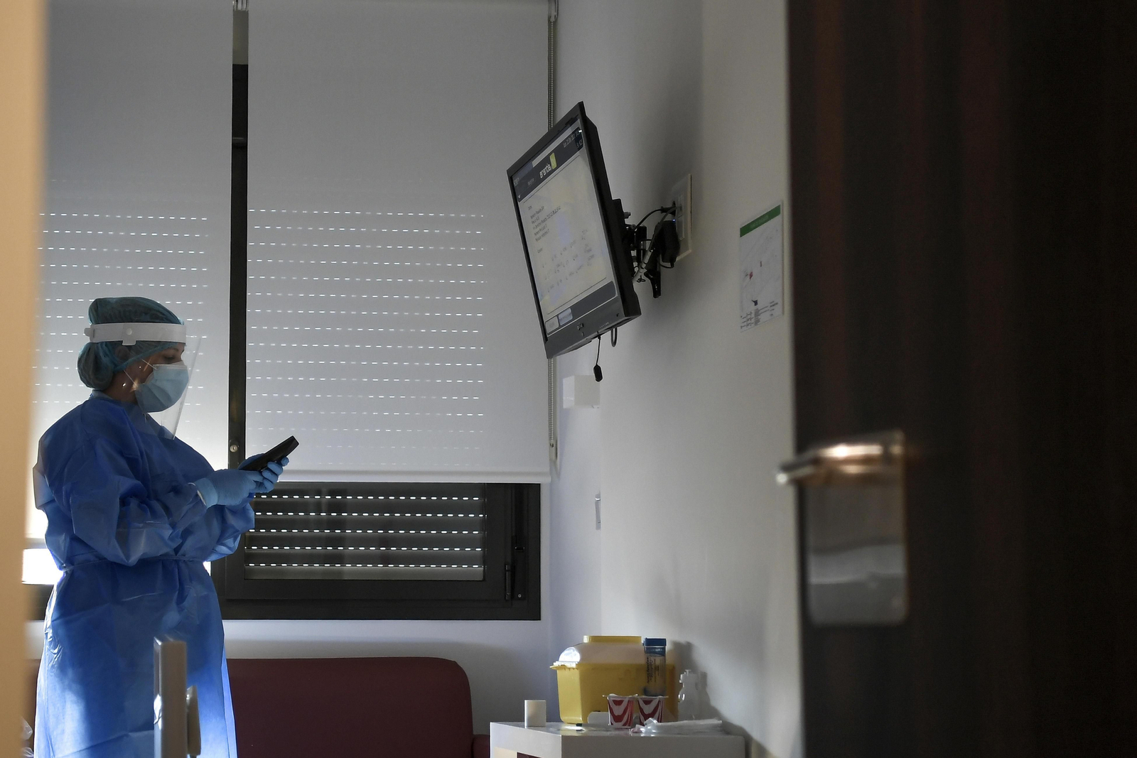 Un profesional sanitario en una habitación con paciente afectado por covid.