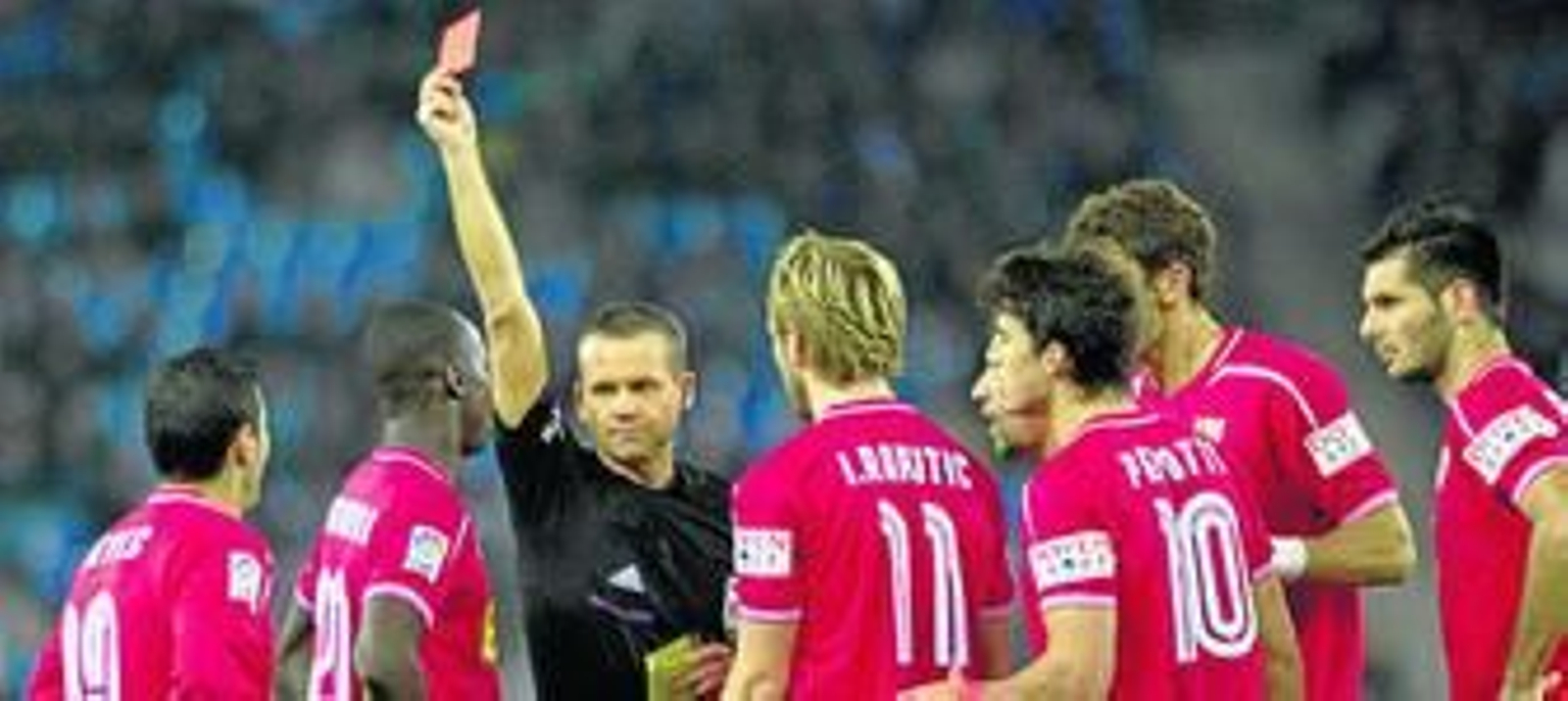 Muñiz Fernández le muestra la roja a Reyes pese a las protestas de Babá, Rakitic, Jesús Navas, Perotti, Fazio y Spahic.