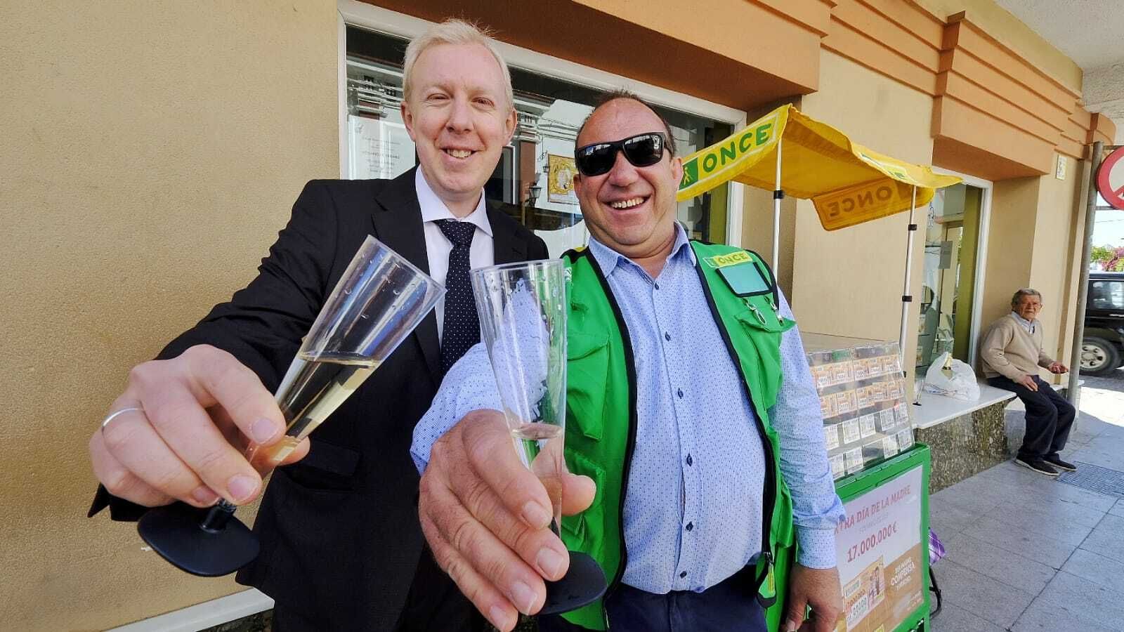 El cuponero Juan Carlos Román y el director de la ONCE en Sanlúcar, Daniel Guerra, brindando hoy por los premios vendidos.