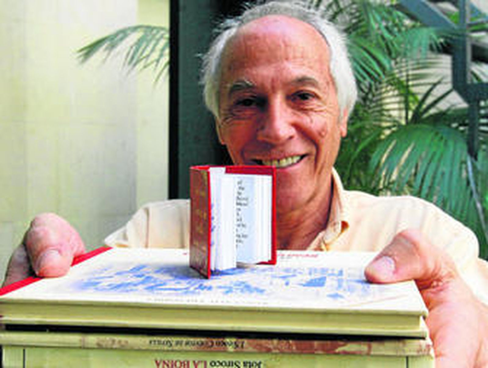 Jota Siroco muestra su libro en miniatura comparándolo con otras de sus publicaciones.