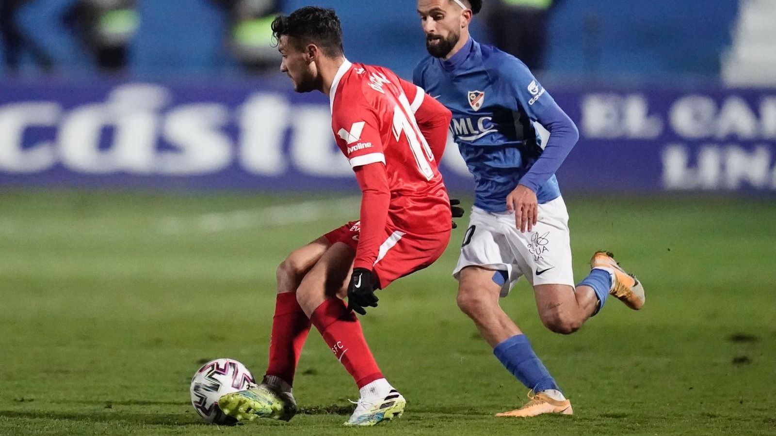 Óscar, el goleador sevillista, hace un pase ante Carnicer.